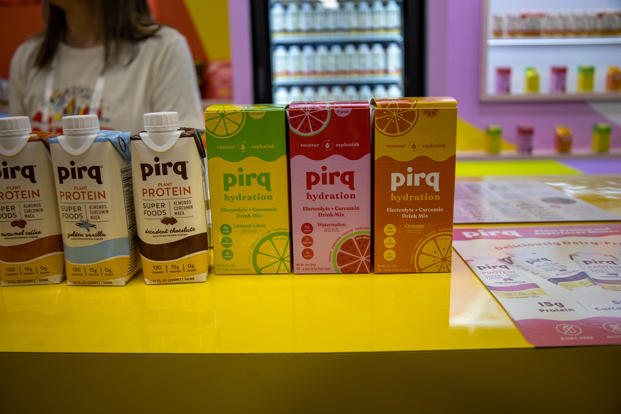 Pirq cartons in protein and hydration flavors on a yellow counter