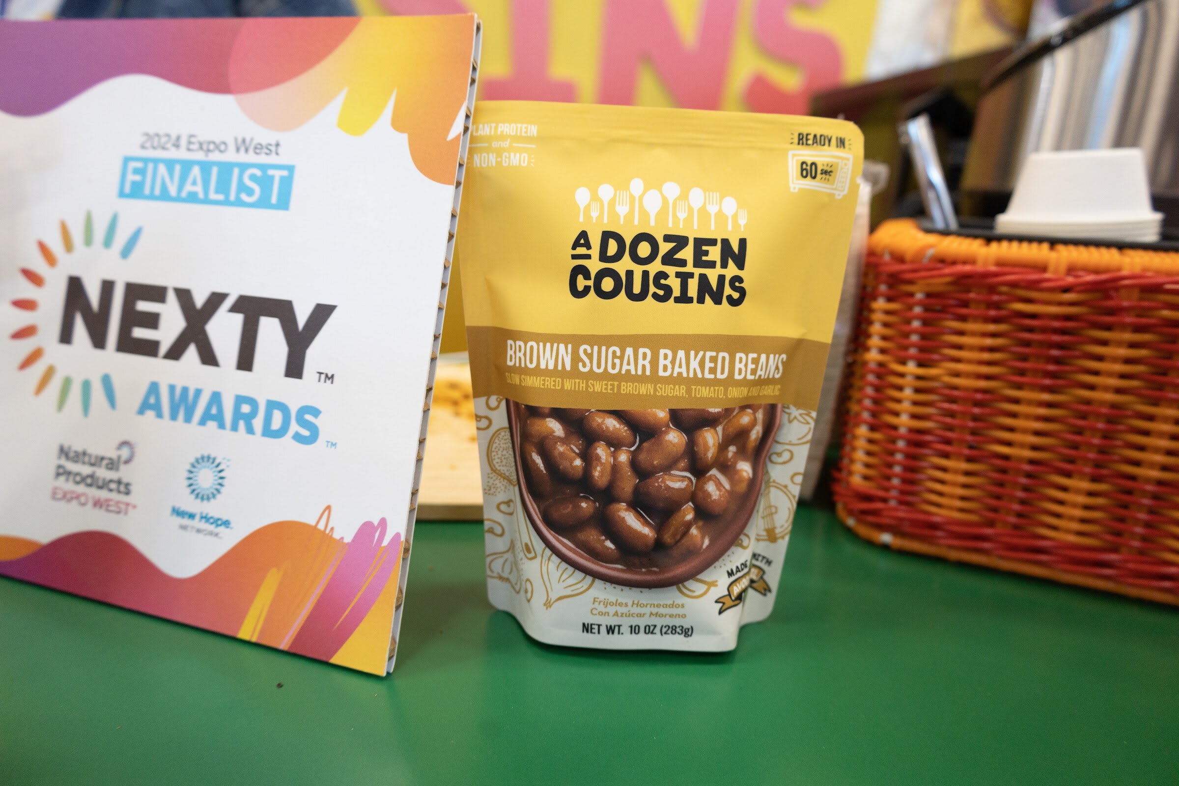 A bag of A Dozen Cousins brown sugar baked beans in front of a Nexty Awards Finalist sign