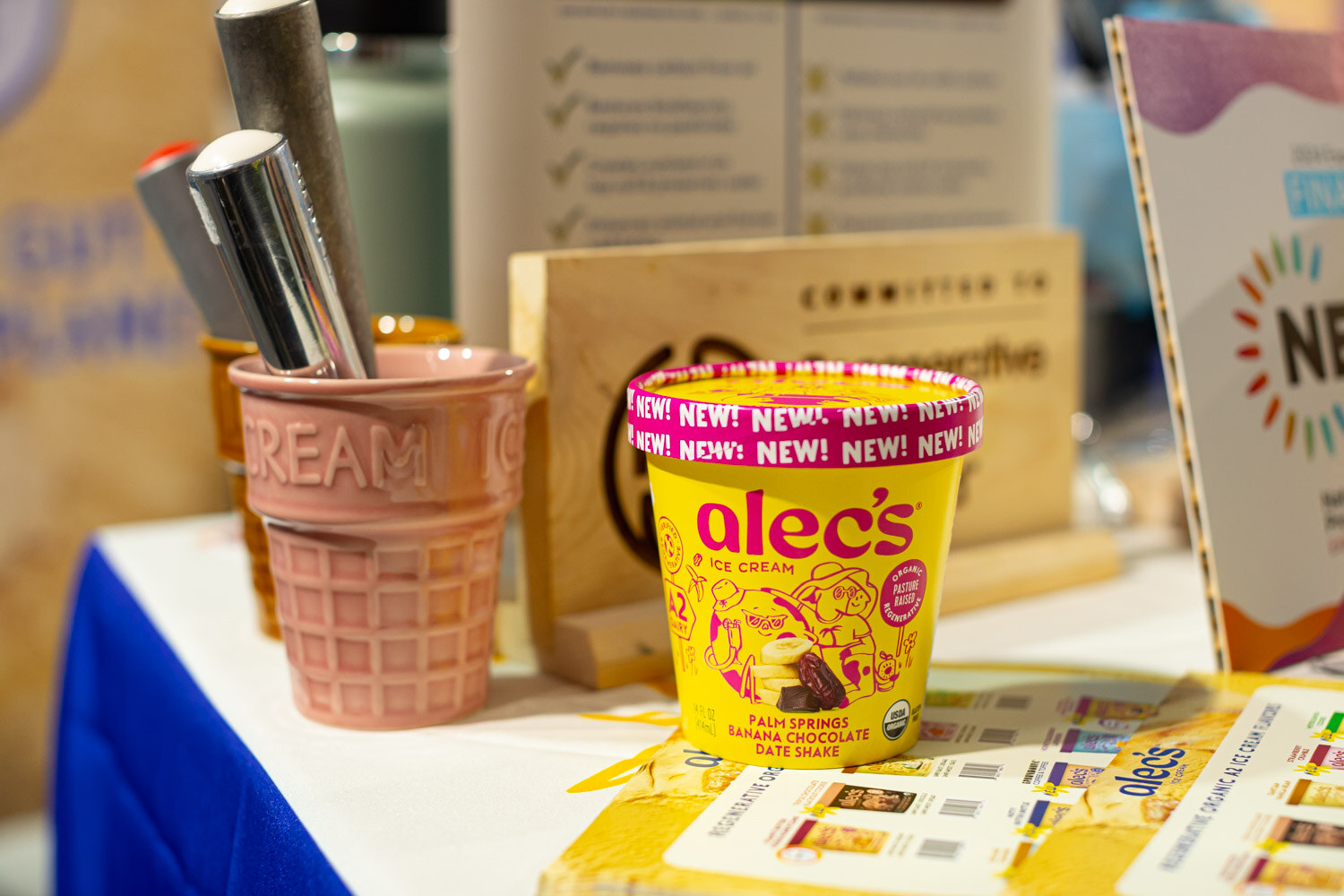 An Alec's ice cream cup on a counter next to an ice cream cone holder