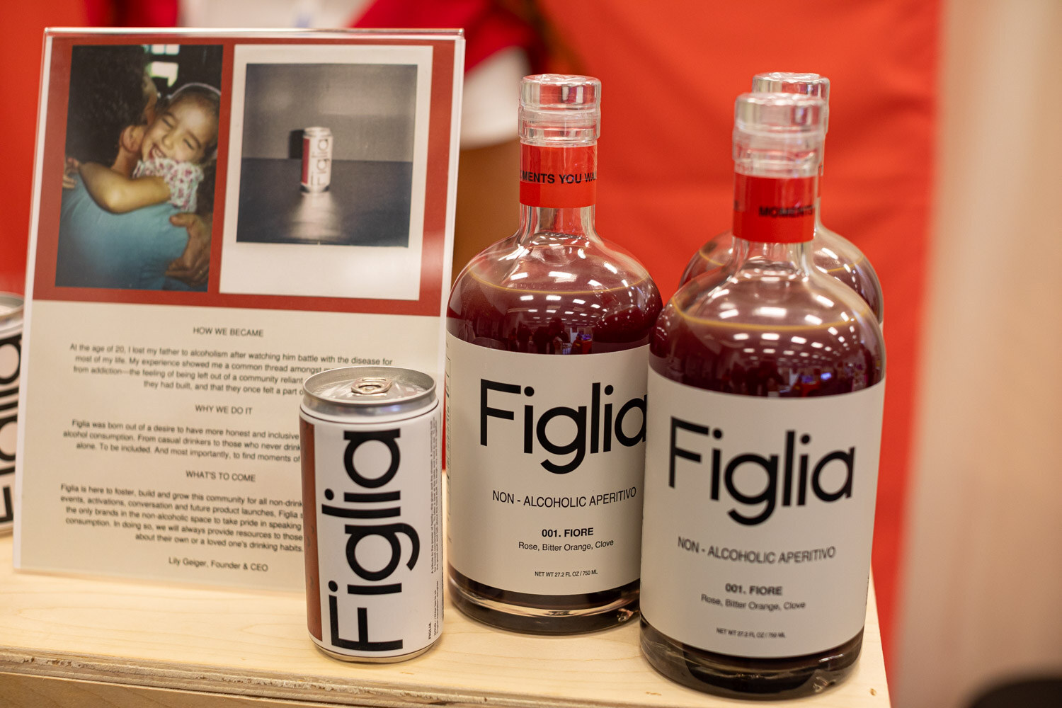 Two Figlia non-alcoholic aperitif bottles and a can in front of a story card