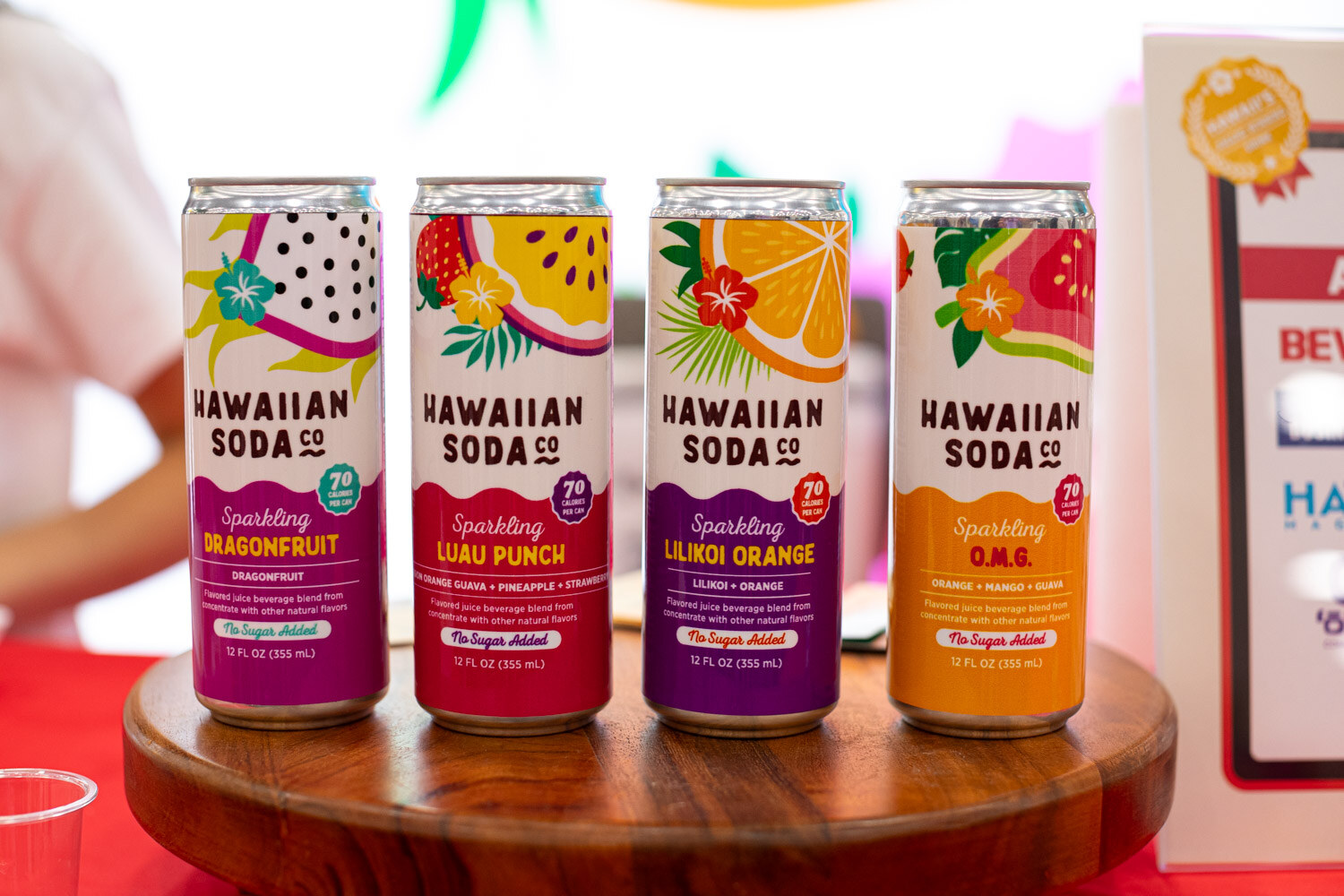 Four Hawaiian Soda Co. sparkling cans on a round wooden tray