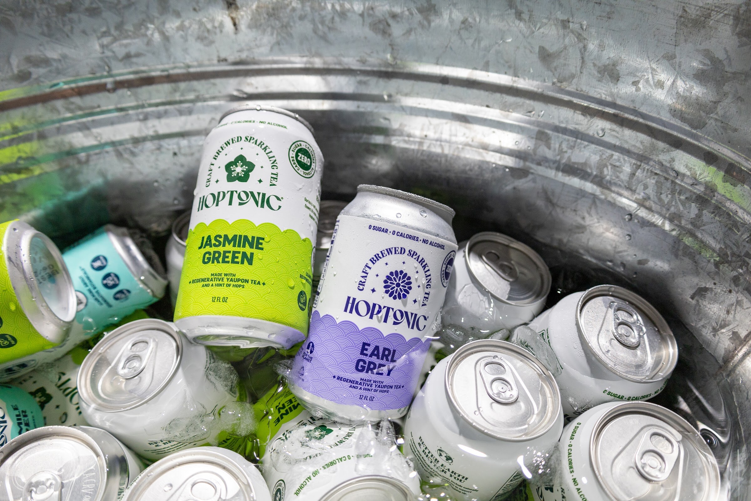 Hoptonic Jasmine Green and Earl Grey cans in a metal tub of ice