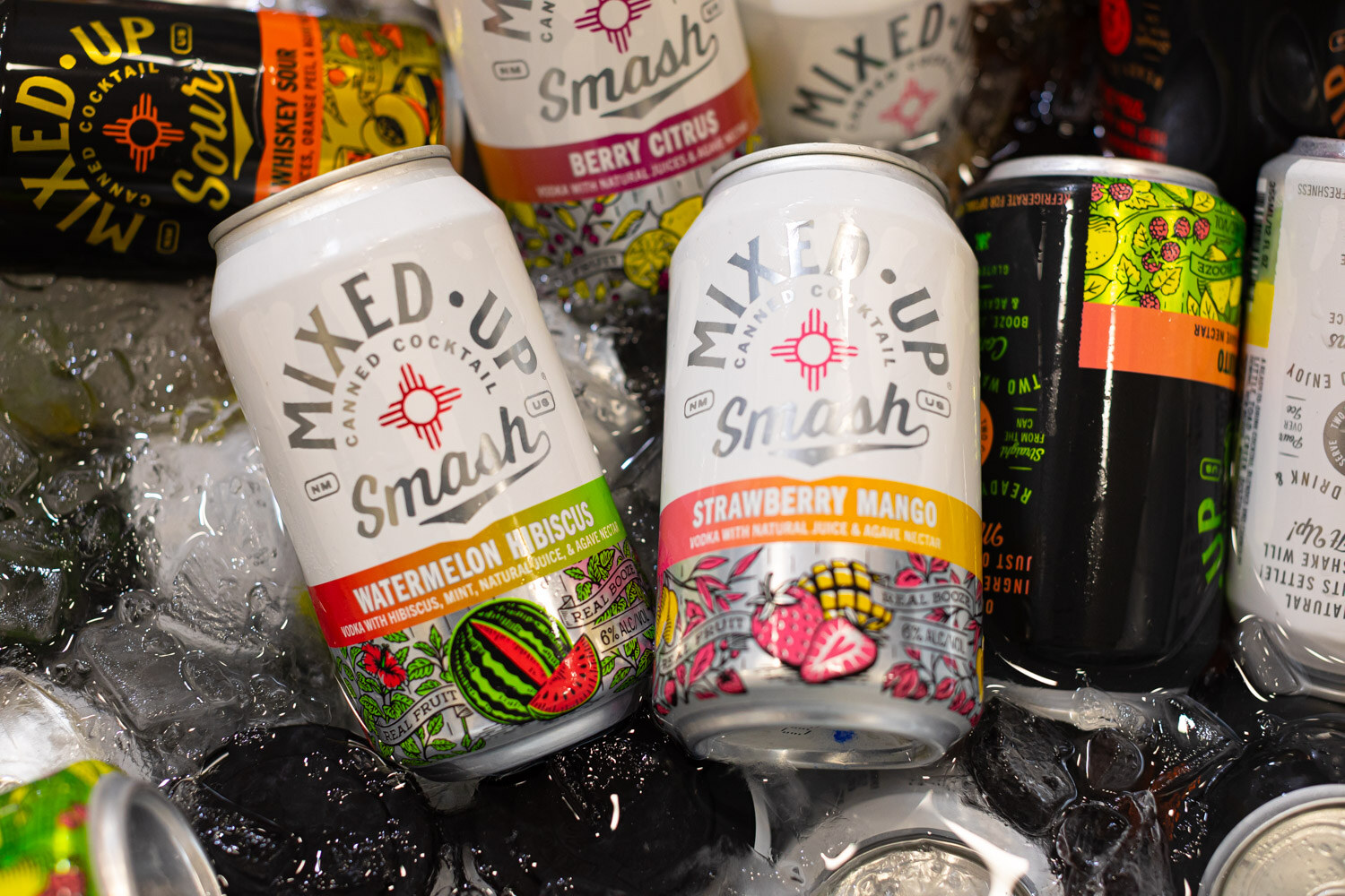 Mixed Up Smash canned cocktails in watermelon hibiscus and strawberry mango sitting in ice