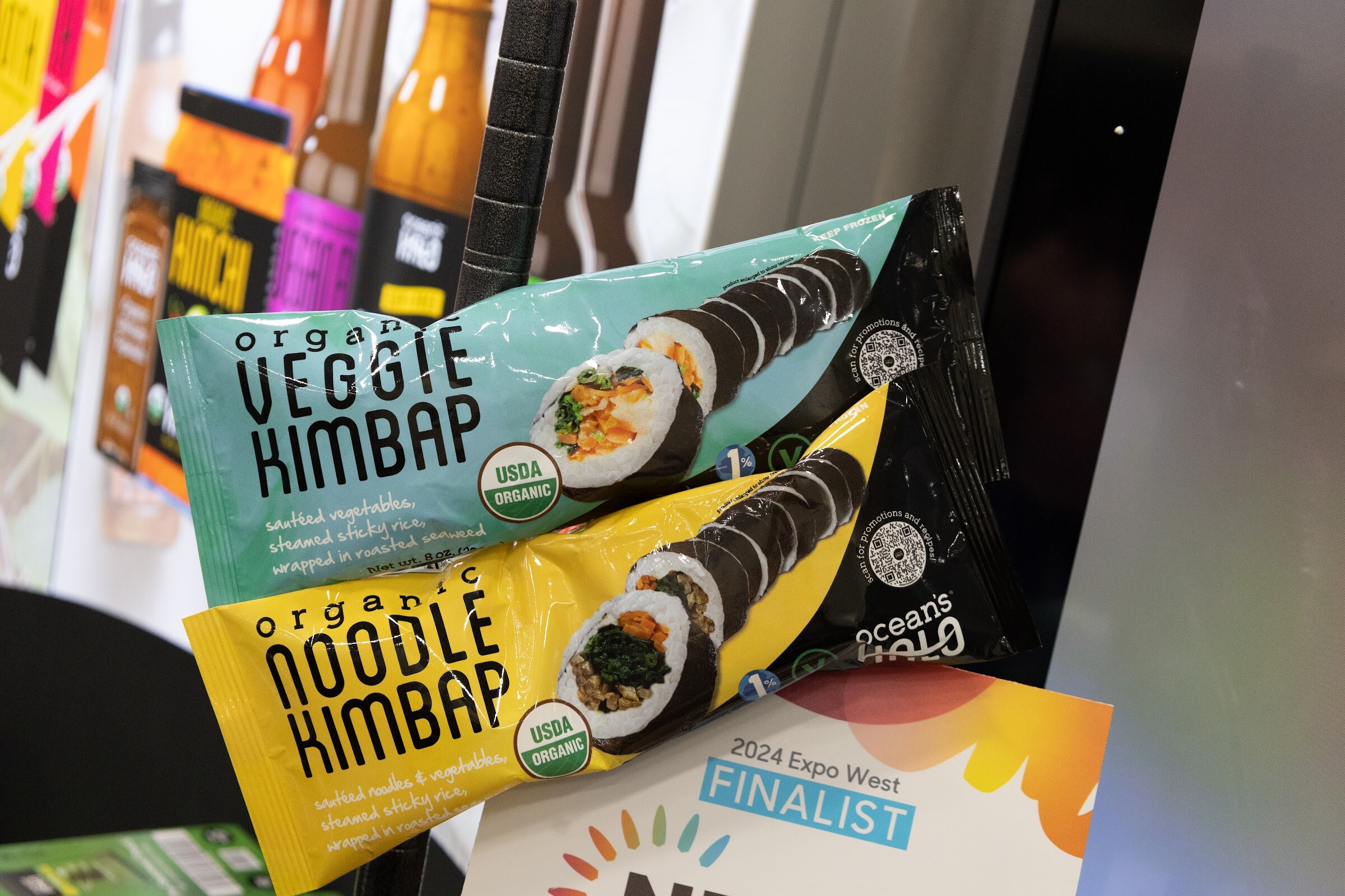 Packages of organic veggie kimbap and noodle kimbap beside a 2024 Expo West Finalist sign