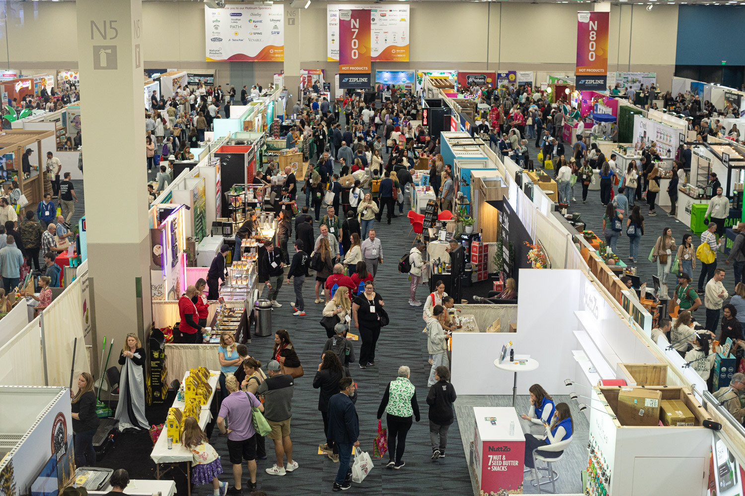 An overhead view of crowded aisles and booths on the Natural Products Expo West exhibit floor