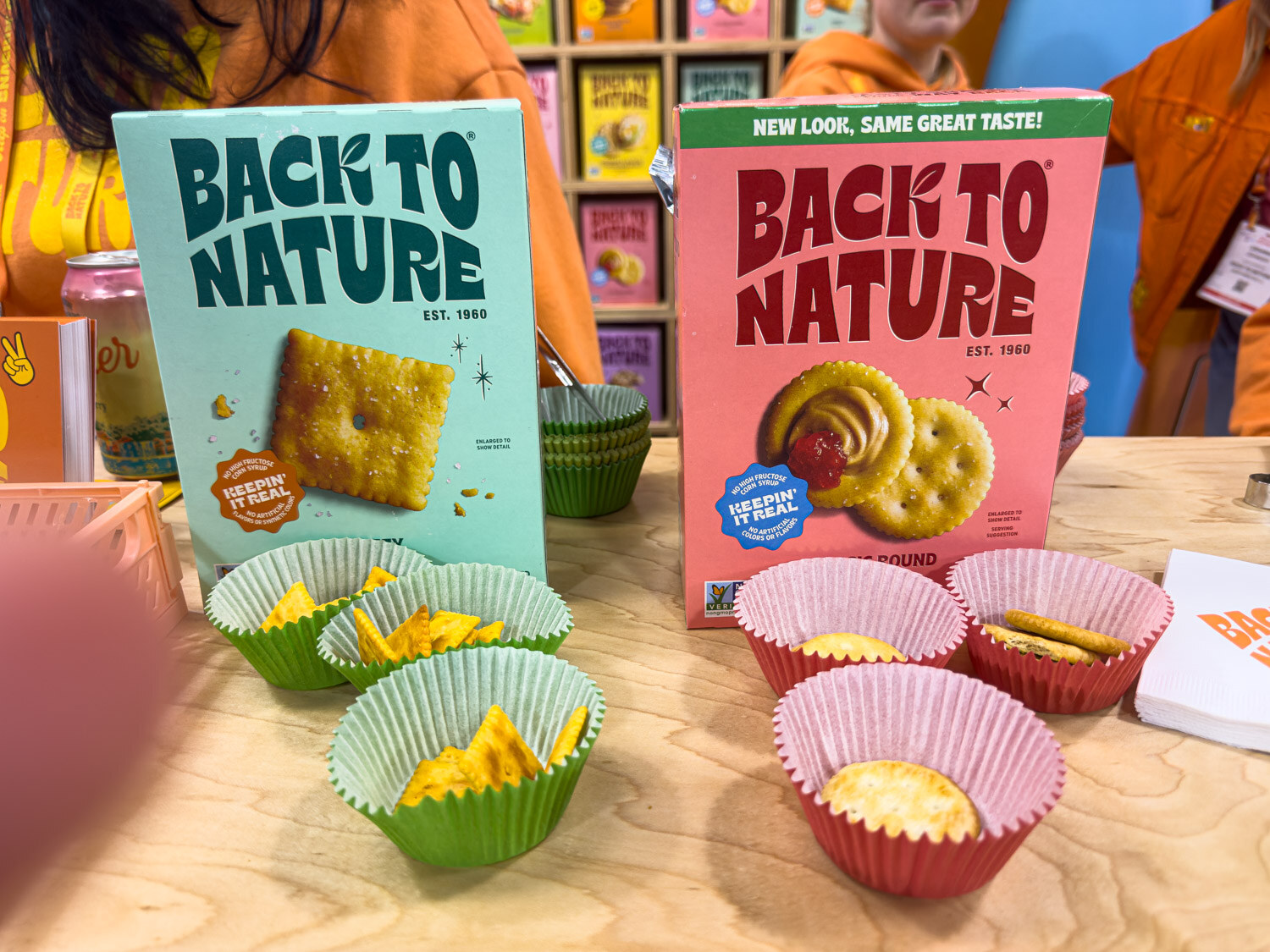 Back to Nature cracker and cookie boxes with sample cups on a wooden table