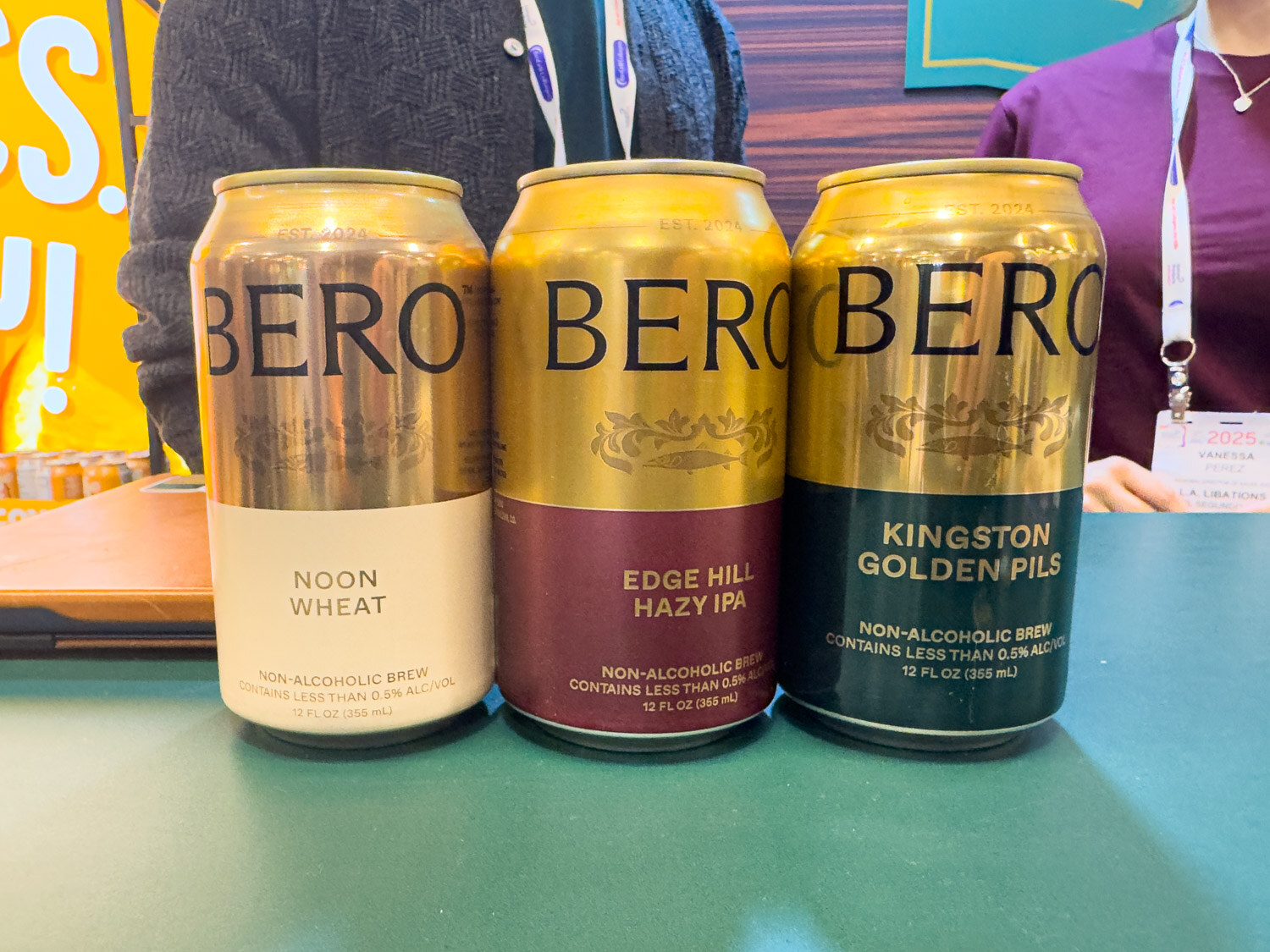 Three gold Bero non-alcoholic beer cans in Noon Wheat, Edge Hill Hazy IPA and Kingston Golden Pils