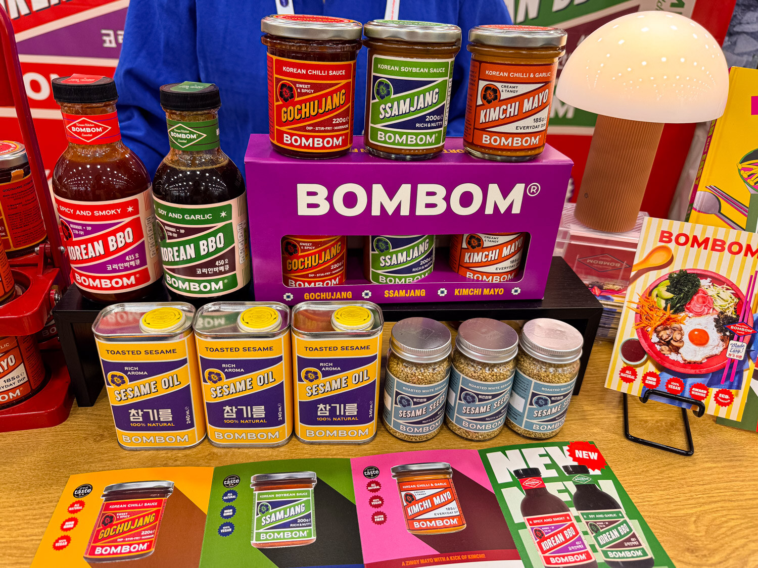 A Bombom display of Korean BBQ sauces and sesame products on a purple stand