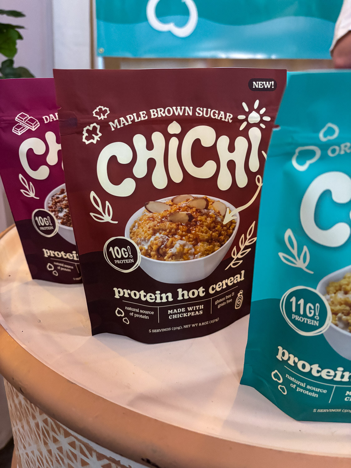 Bags of Chichi protein hot cereal on a round white display