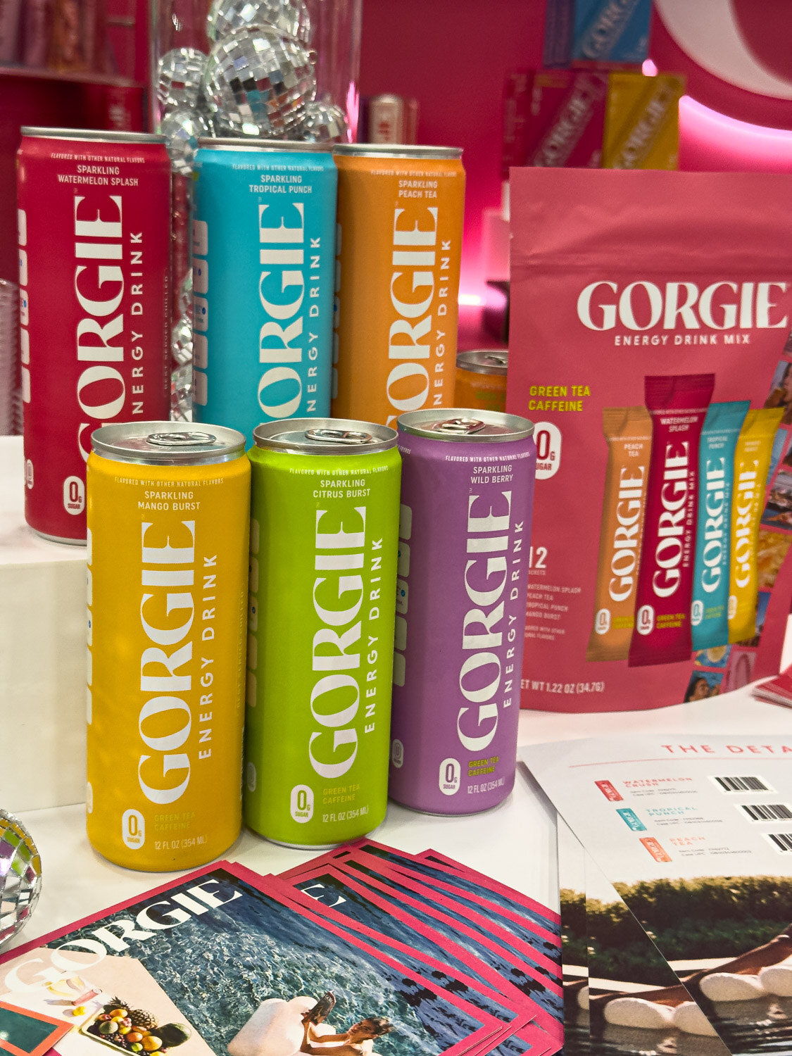 Colorful Gorgie energy drink cans and mix packets on a display table