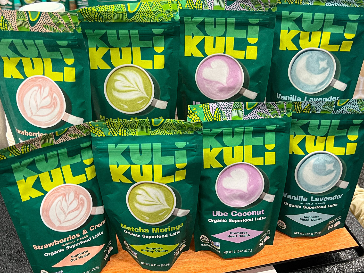 Rows of Kuli Kuli organic superfood latte bags in several flavors on a shelf