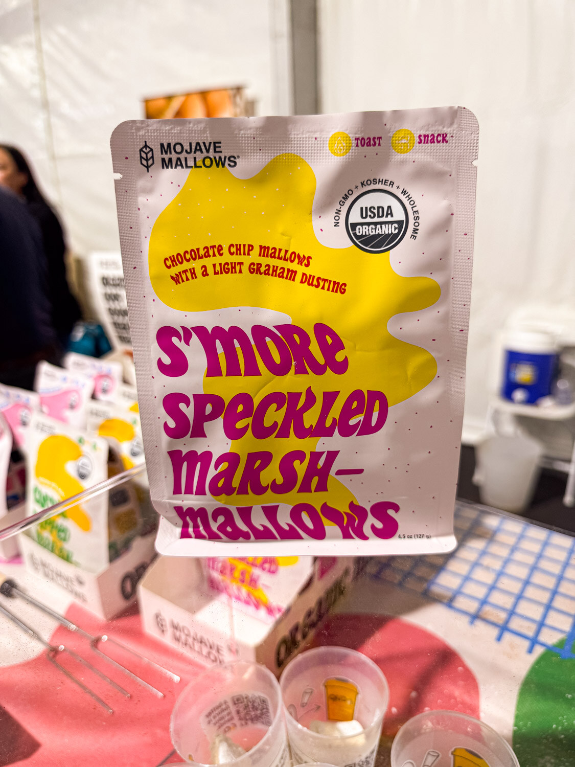 A hand holding a bag of Mojave Mallows S'more Speckled Marshmallows