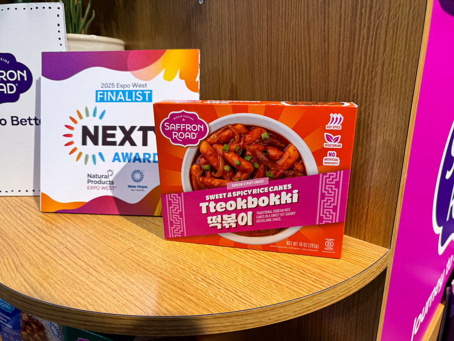 A Saffron Road Sweet and Spicy Rice Cakes box beside a 2025 Nexty Awards Finalist sign