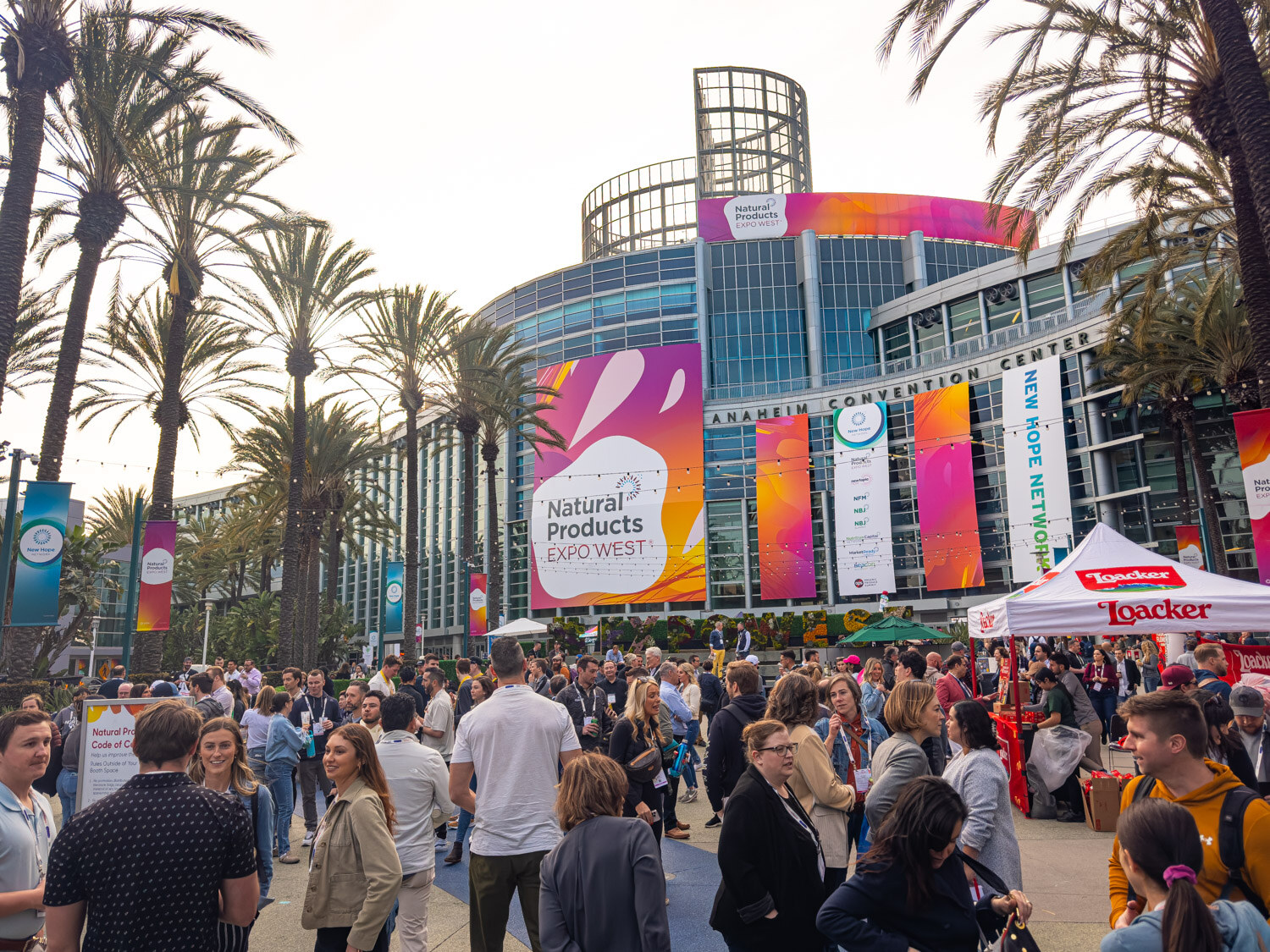 The front of the Anaheim Convention Center with Natural Products Expo West banners and a crowd of attendees below