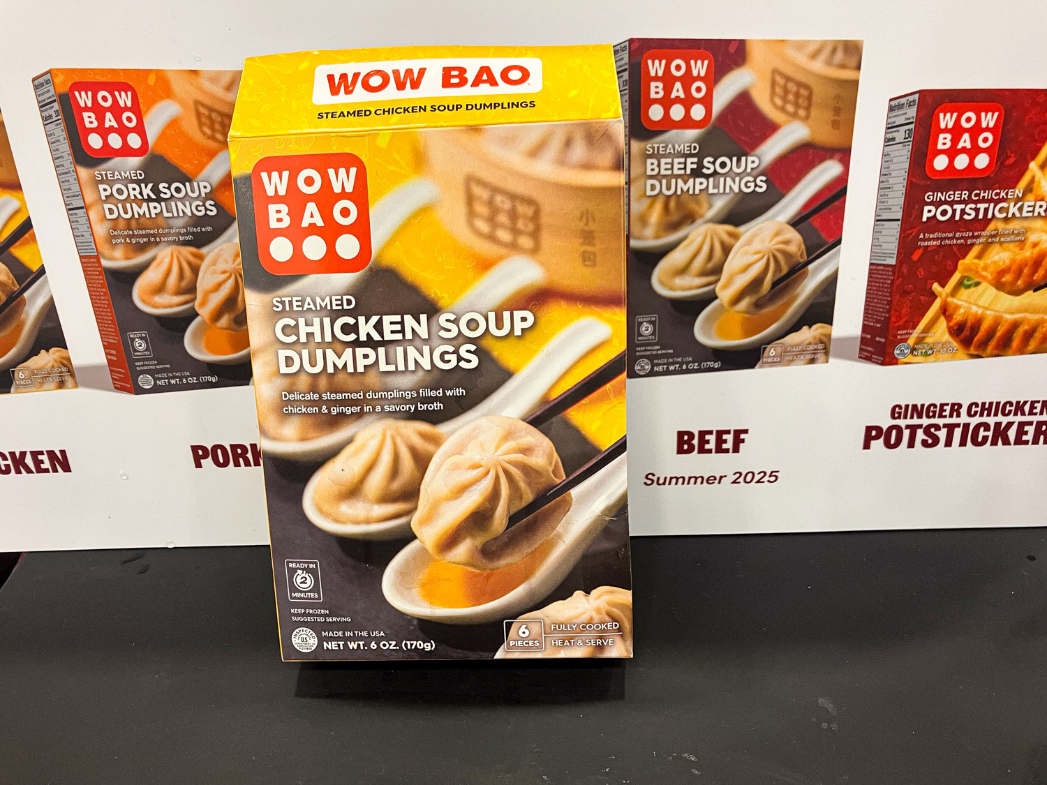 A box of Wow Bao steamed chicken soup dumplings in front of other Wow Bao boxes
