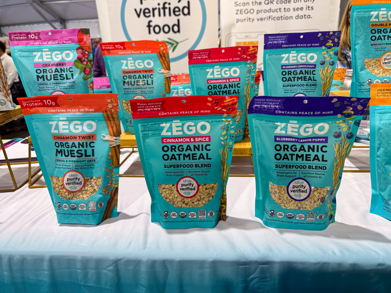 Bags of Zego organic muesli and oatmeal on a table with a verified food sign