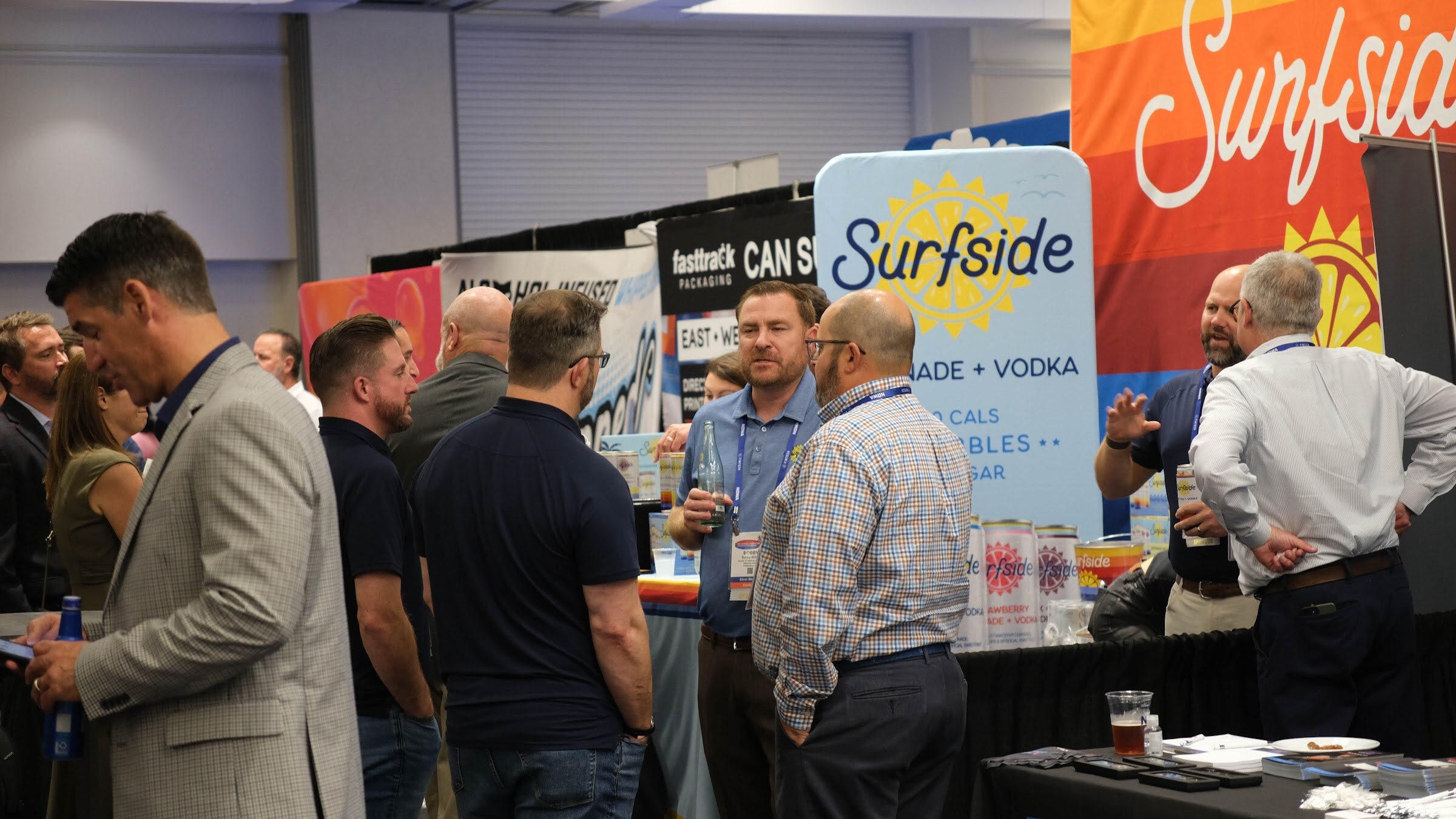 Group of attendees talking in front of a booth with a large Surfside Lemonade + Vodka sign.