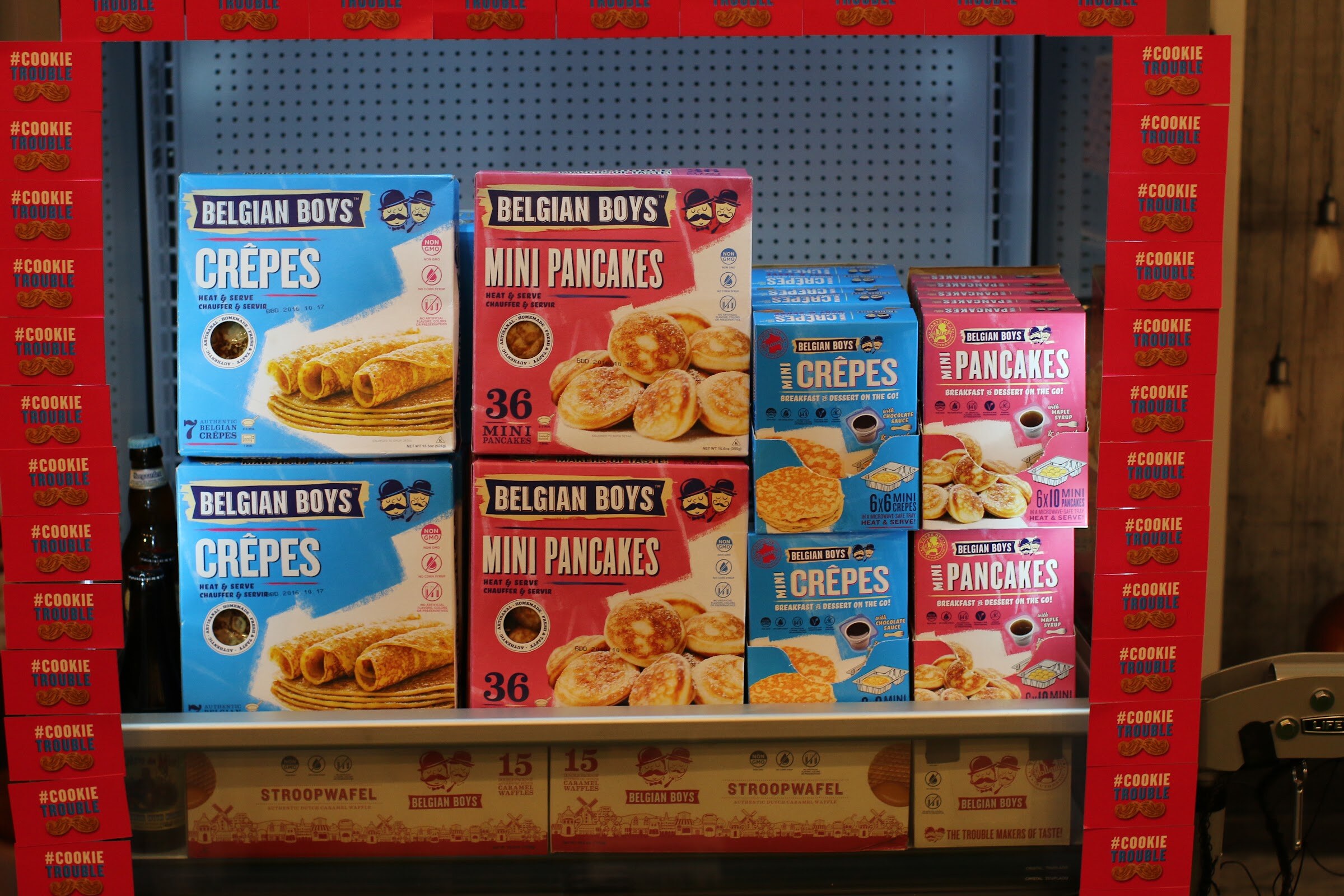 Shelf of Belgian Boys crepes and mini pancake boxes surrounded by red #CookieTrouble boxes.