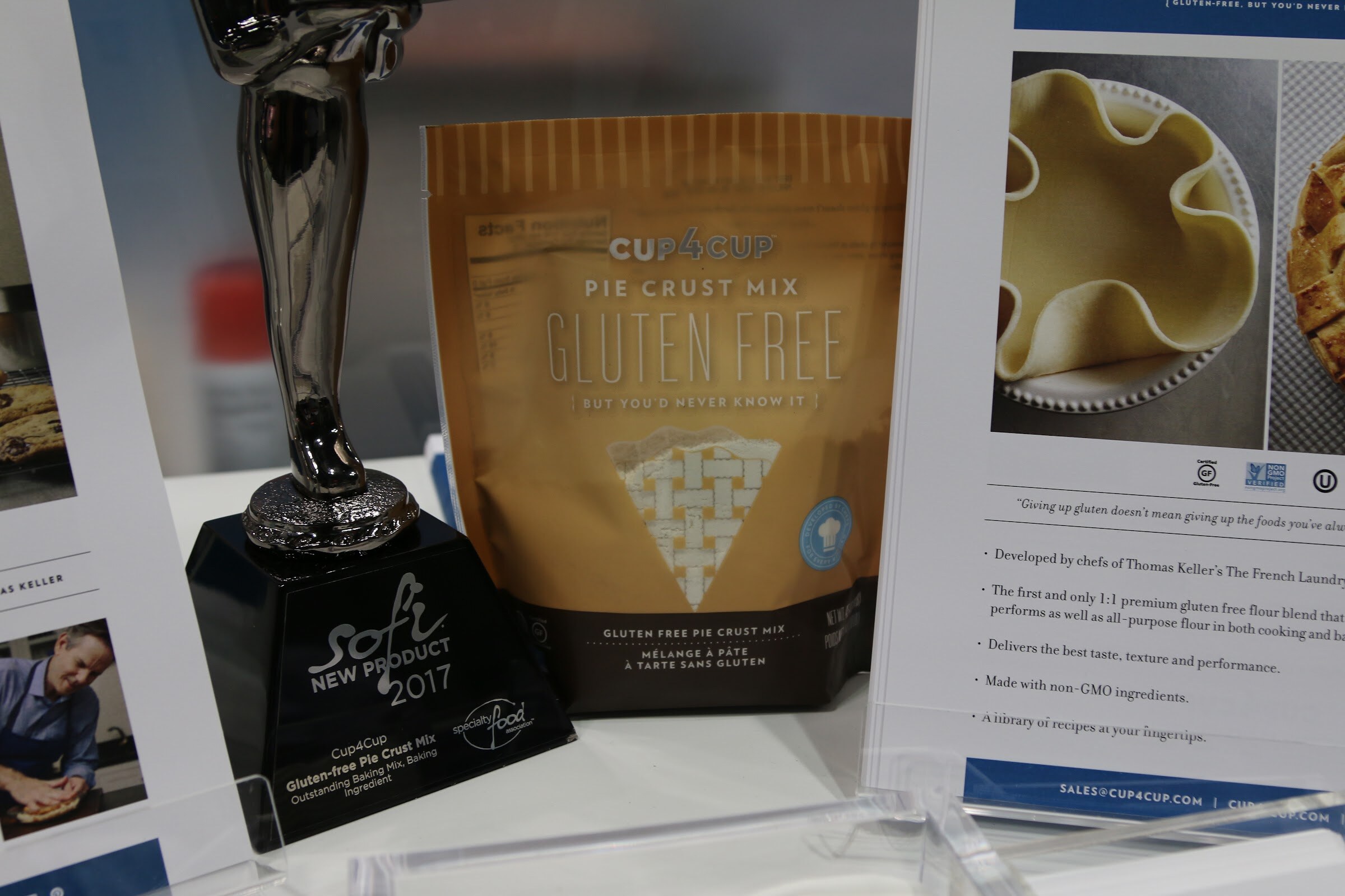 A bag of Cup4Cup gluten-free pie crust mix next to a black sofi New Product 2017 award trophy and a product information sheet.