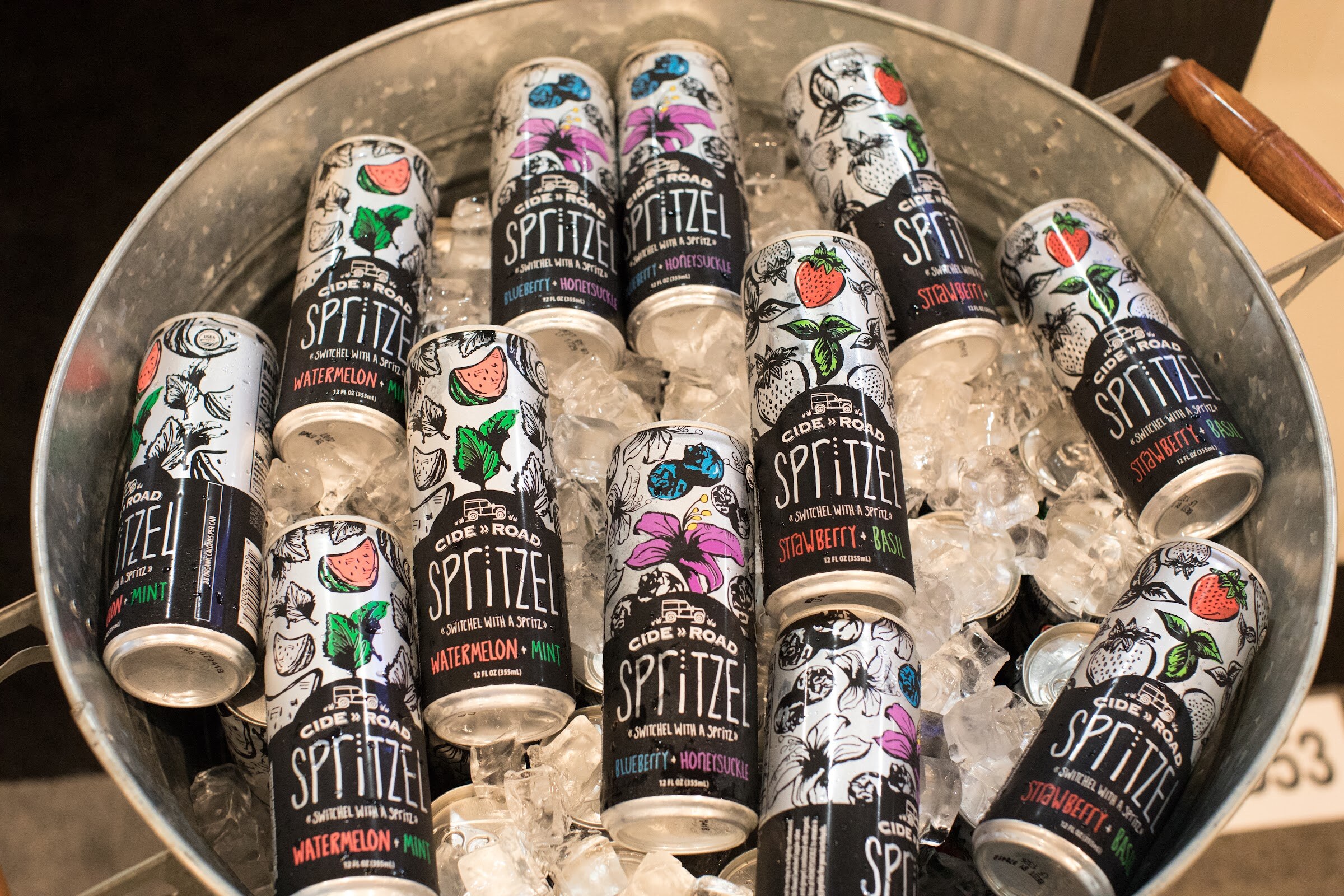 Black and white Cide Road Spritzer cans arranged in a galvanized tub of ice.