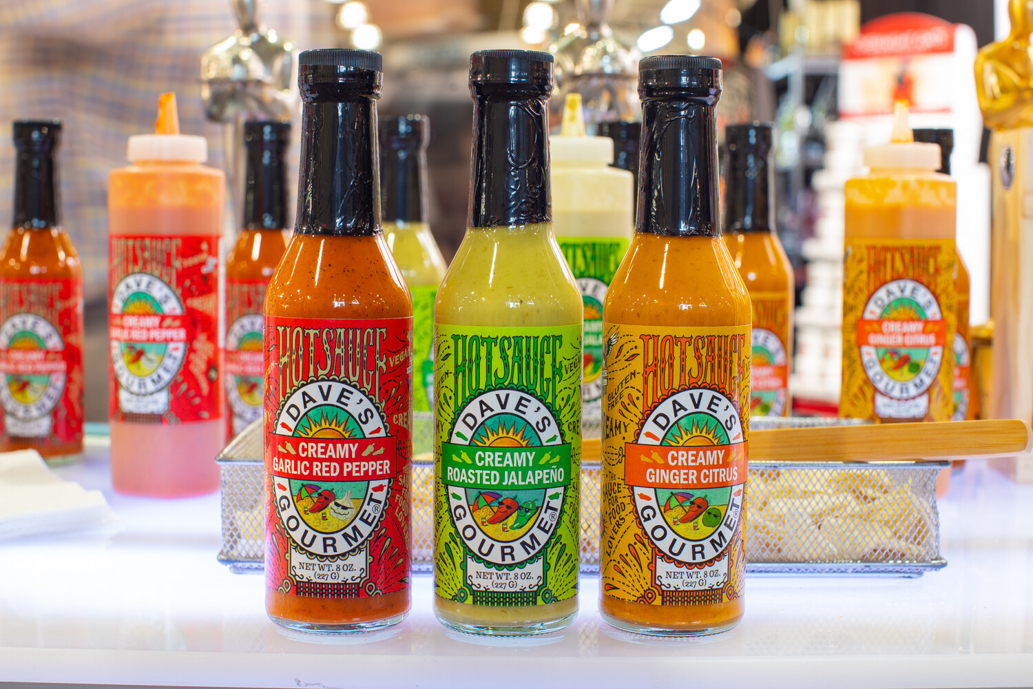 Bottles of Dave's Gourmet creamy garlic red pepper, roasted jalapeno and ginger citrus sauces.