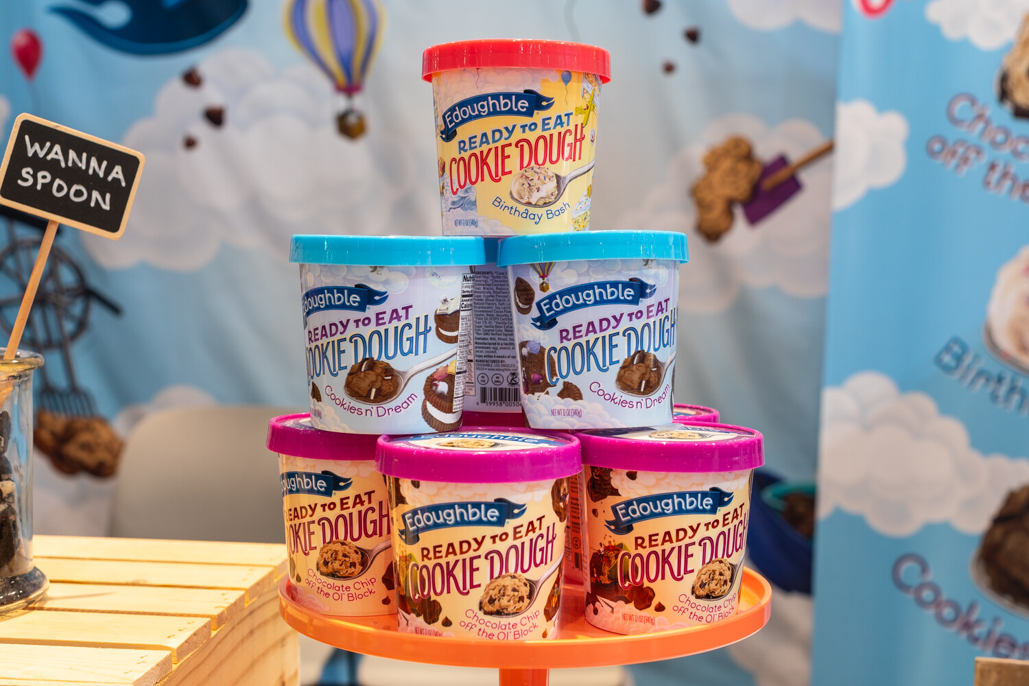 A tower of Edoughble cookie dough cups on an orange stand.