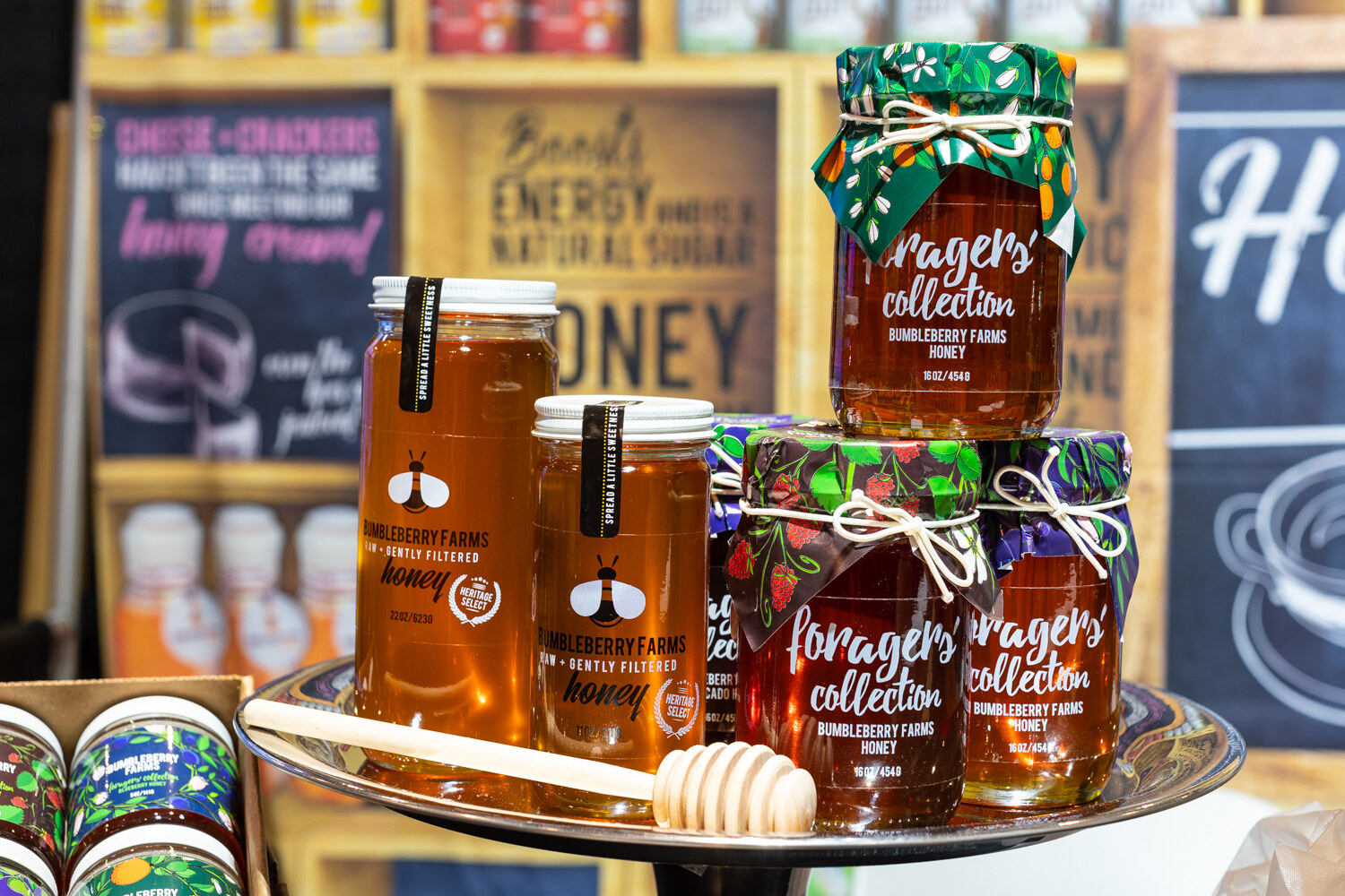 Honey jars with wrapped lids and a honey dipper.