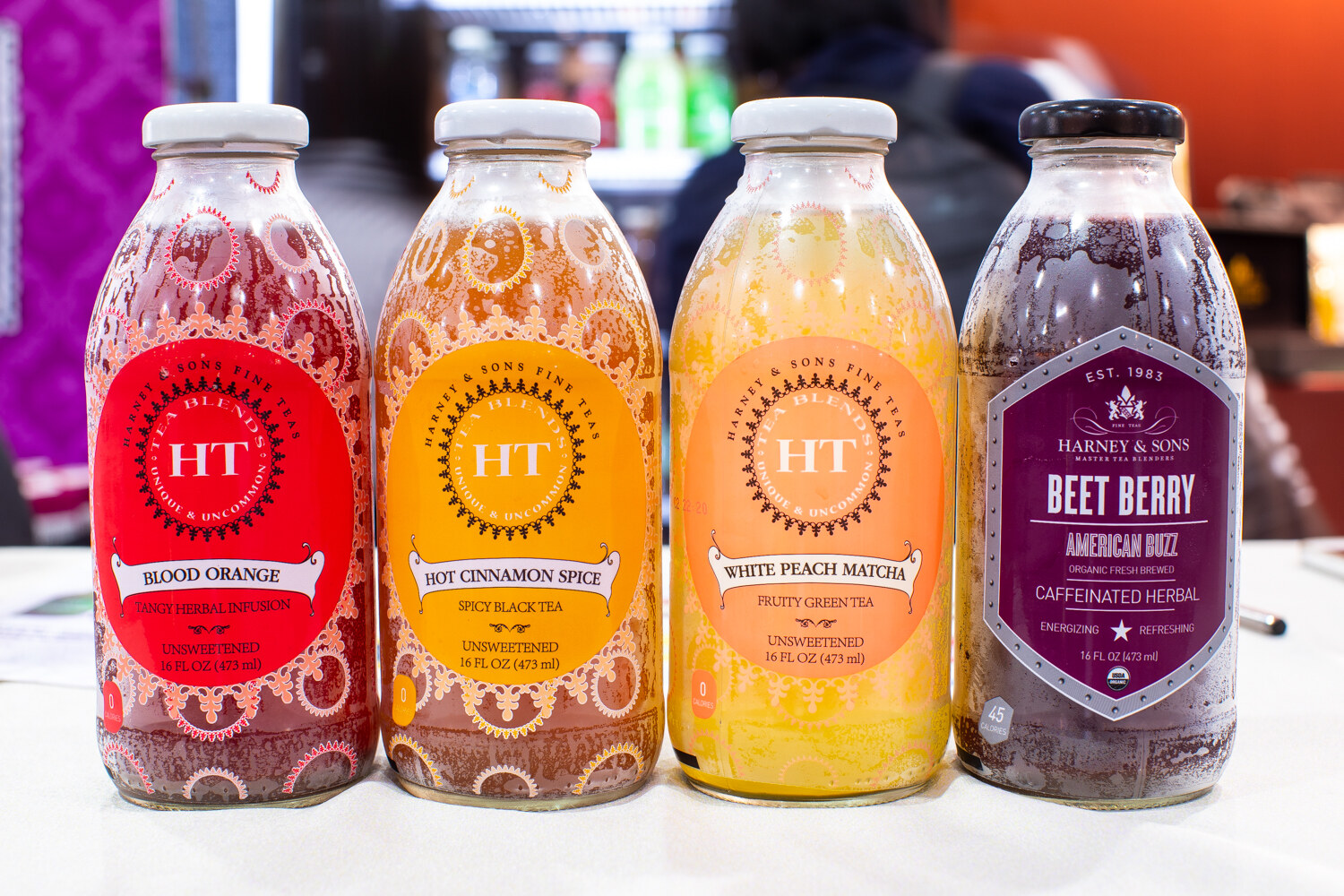 Four bottles of Harney & Sons tea including Blood Orange and Beet Berry.