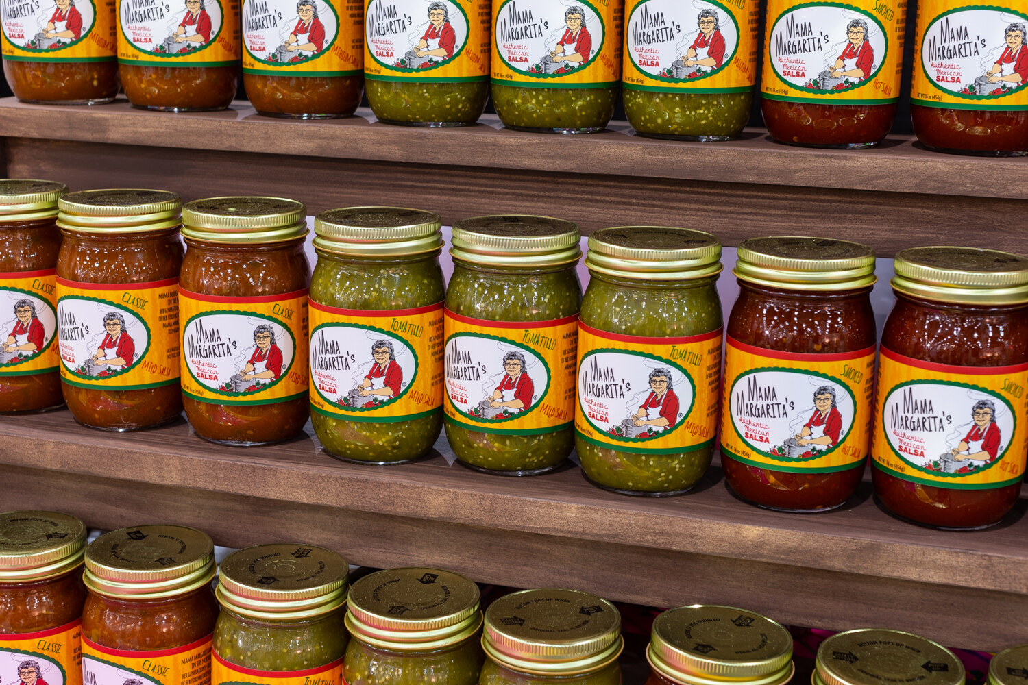Rows of salsa jars with red and green salsas.