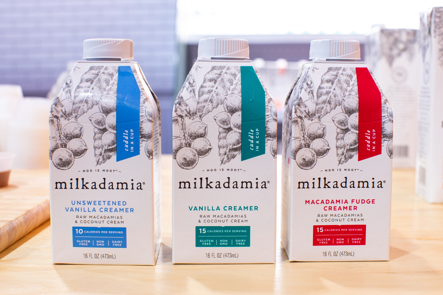 Three cartons of Milkadamia in vanilla, unsweetened vanilla and macadamia fudge.