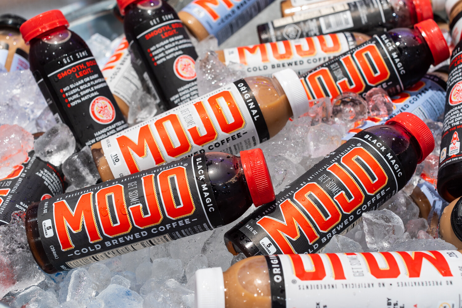 Bottles of Mojo cold-brewed coffee piled in ice.