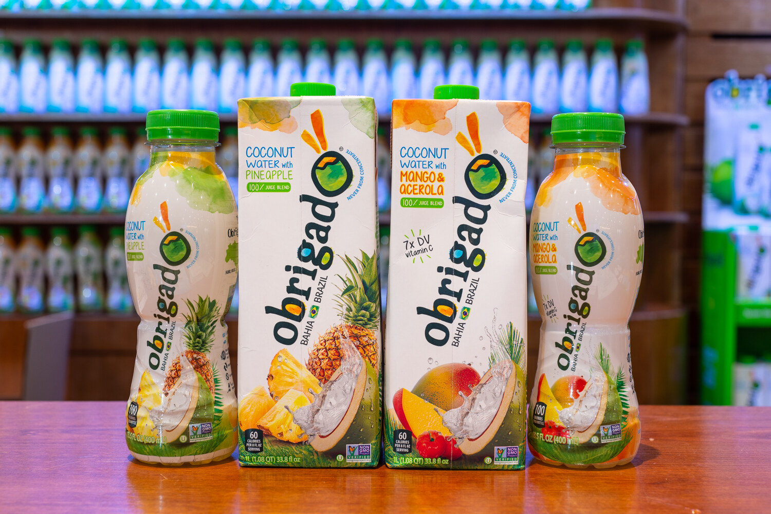 Bottles and cartons of Obrigado coconut water with pineapple and mango.