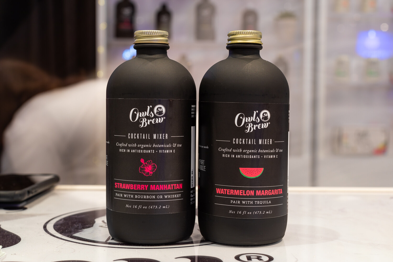 Two black bottles labeled Owl's Brew.