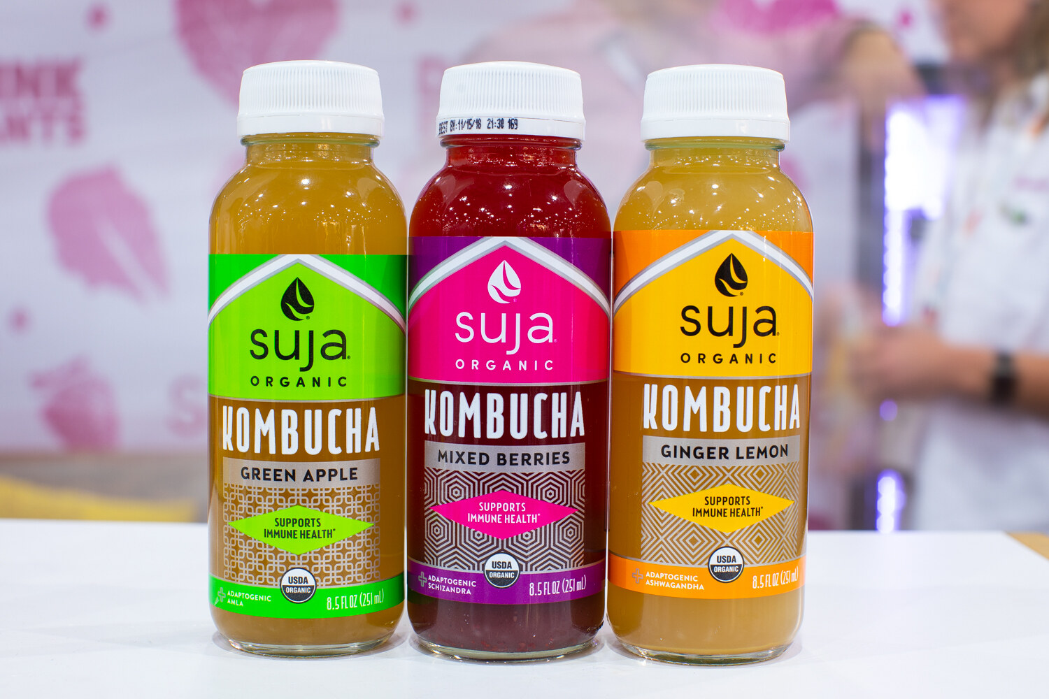 Bottles of Suja kombucha in green apple, mixed berries and ginger lemon.