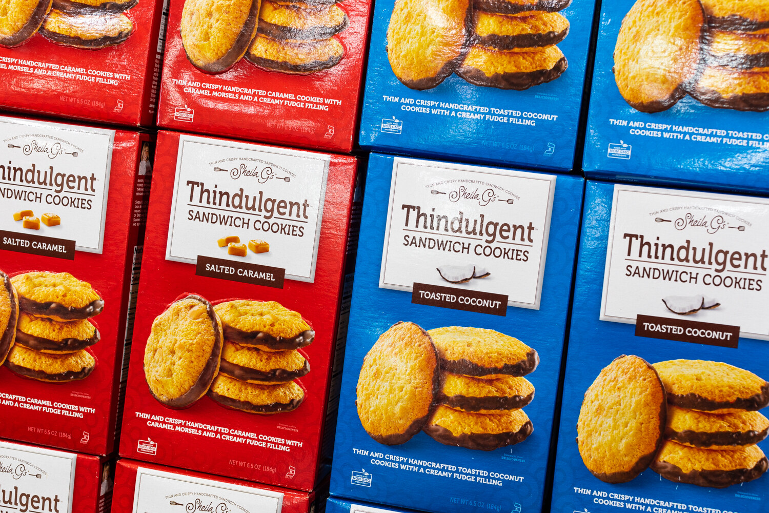 Red and blue boxes of Thindulgent salted caramel and toasted coconut cookies.
