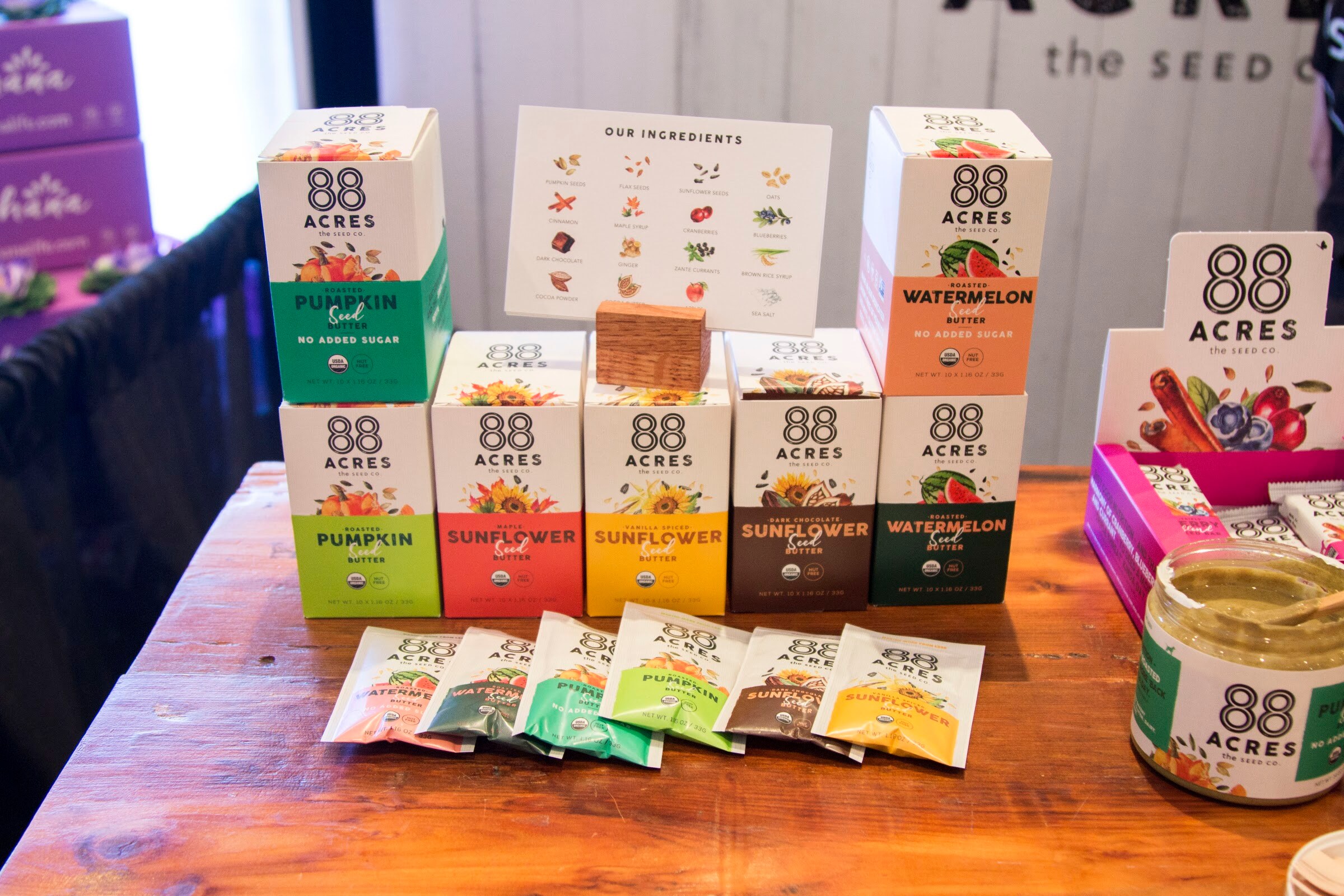 Photo of 88 Acres seed butter boxes and pouches on a wooden table.