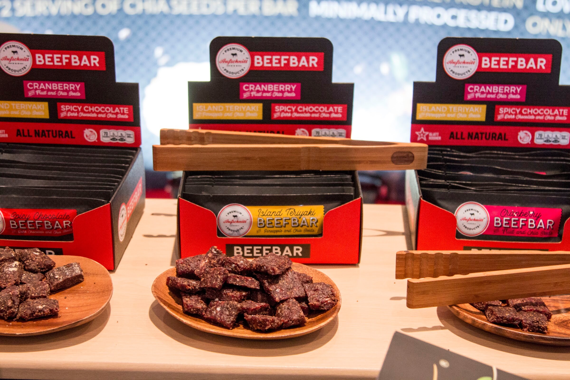 Photo of Beefbar boxes and a plate of sliced bars with tongs.