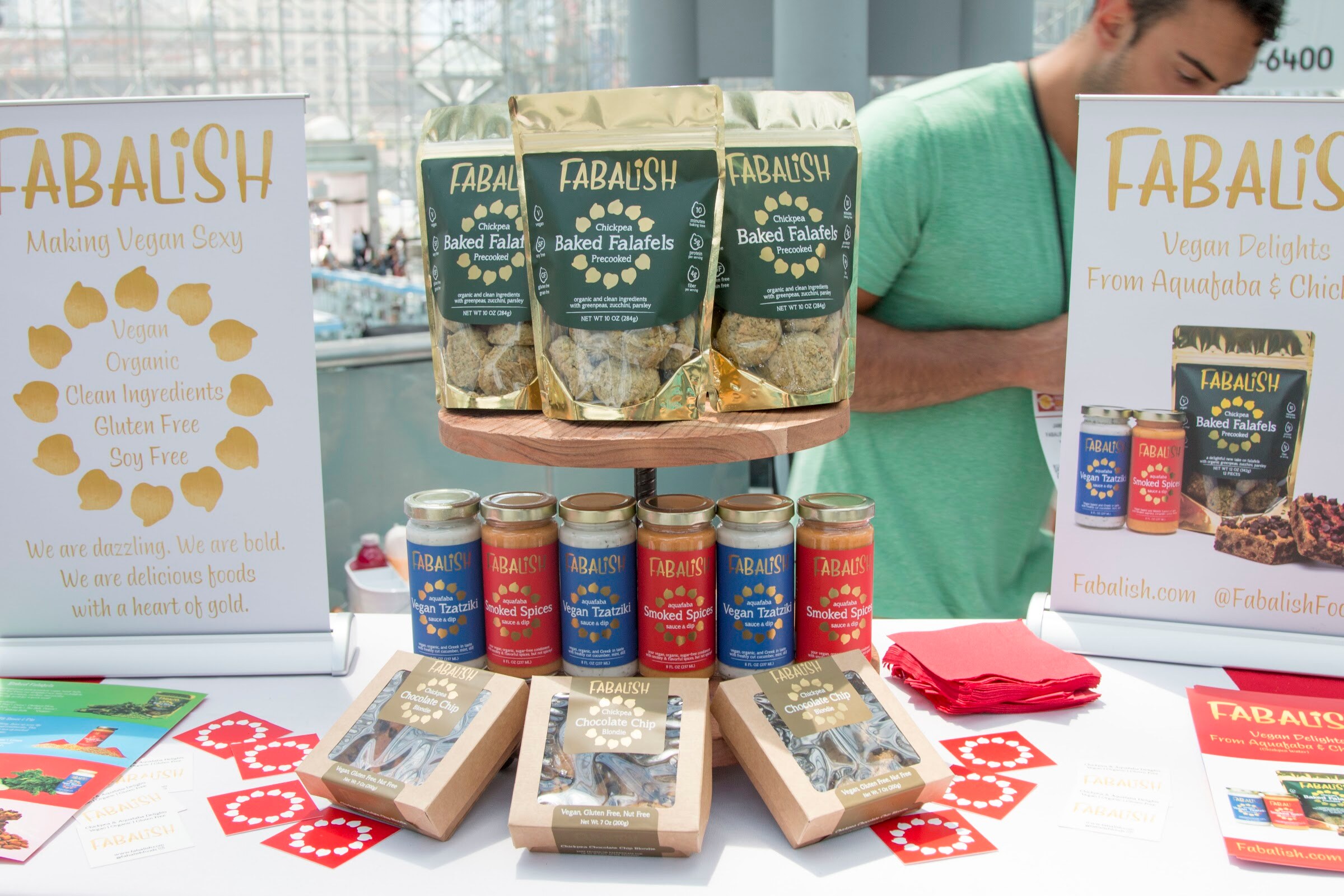 Photo of jars and bags of Fabalish baked falafels with an exhibitor behind the table.