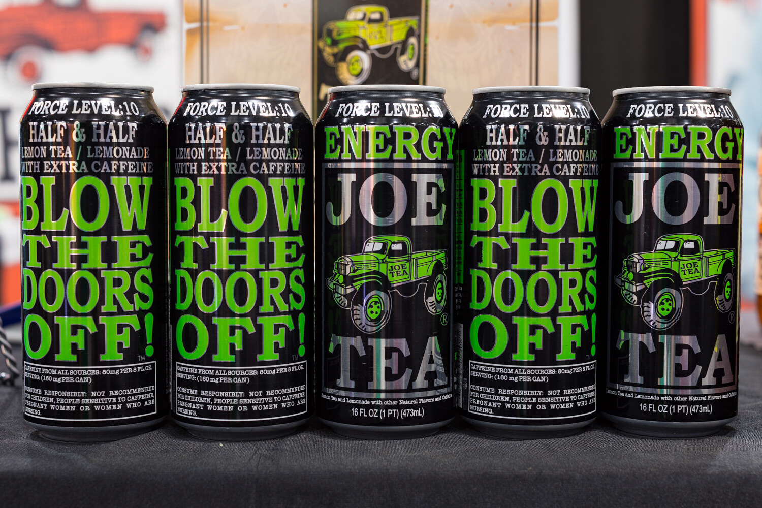 Photo of black Force Level Joe Tea cans lined up on a table.