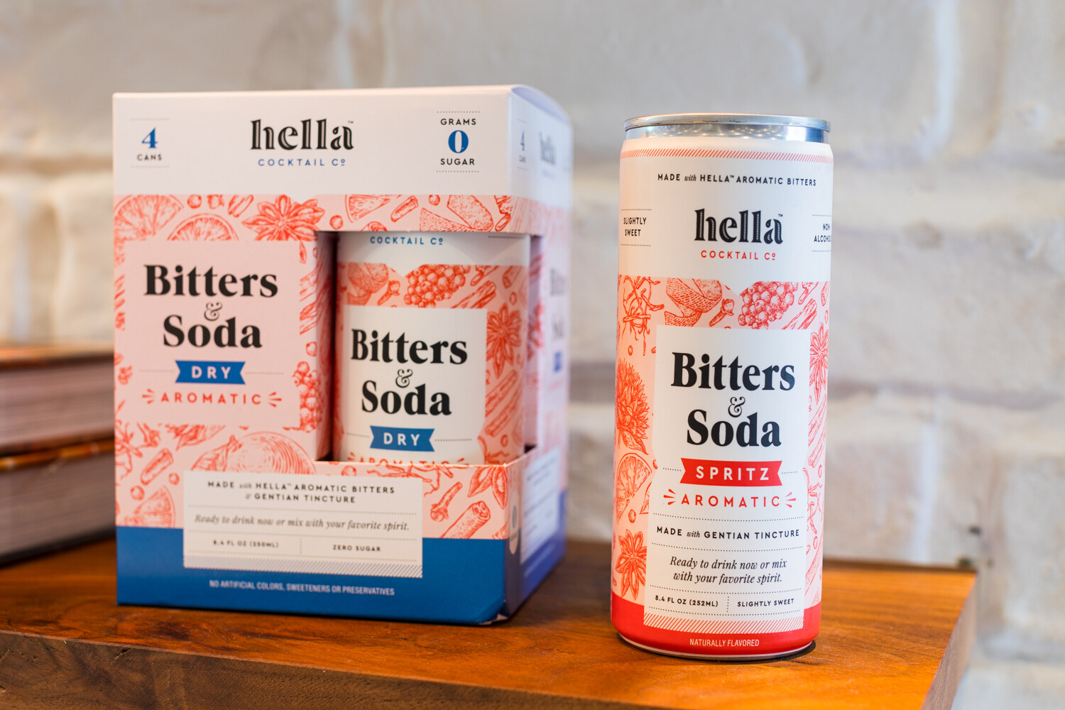 Photo of hella Bitters and Soda boxes and a can on a shelf.