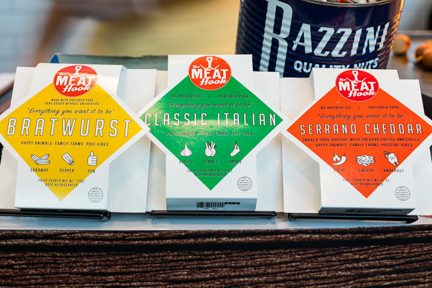 Photo of Meat Hook bratwurst, classic Italian and serrano cheddar sausage packages.