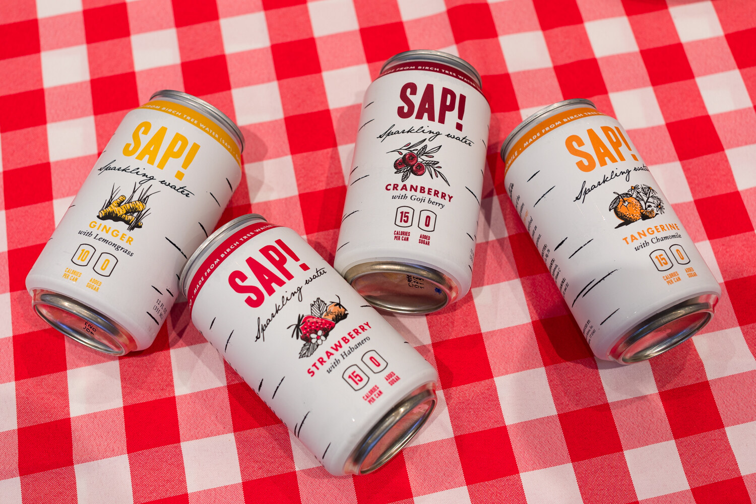 Photo of cans of SAP! sparkling water on a red gingham cloth.