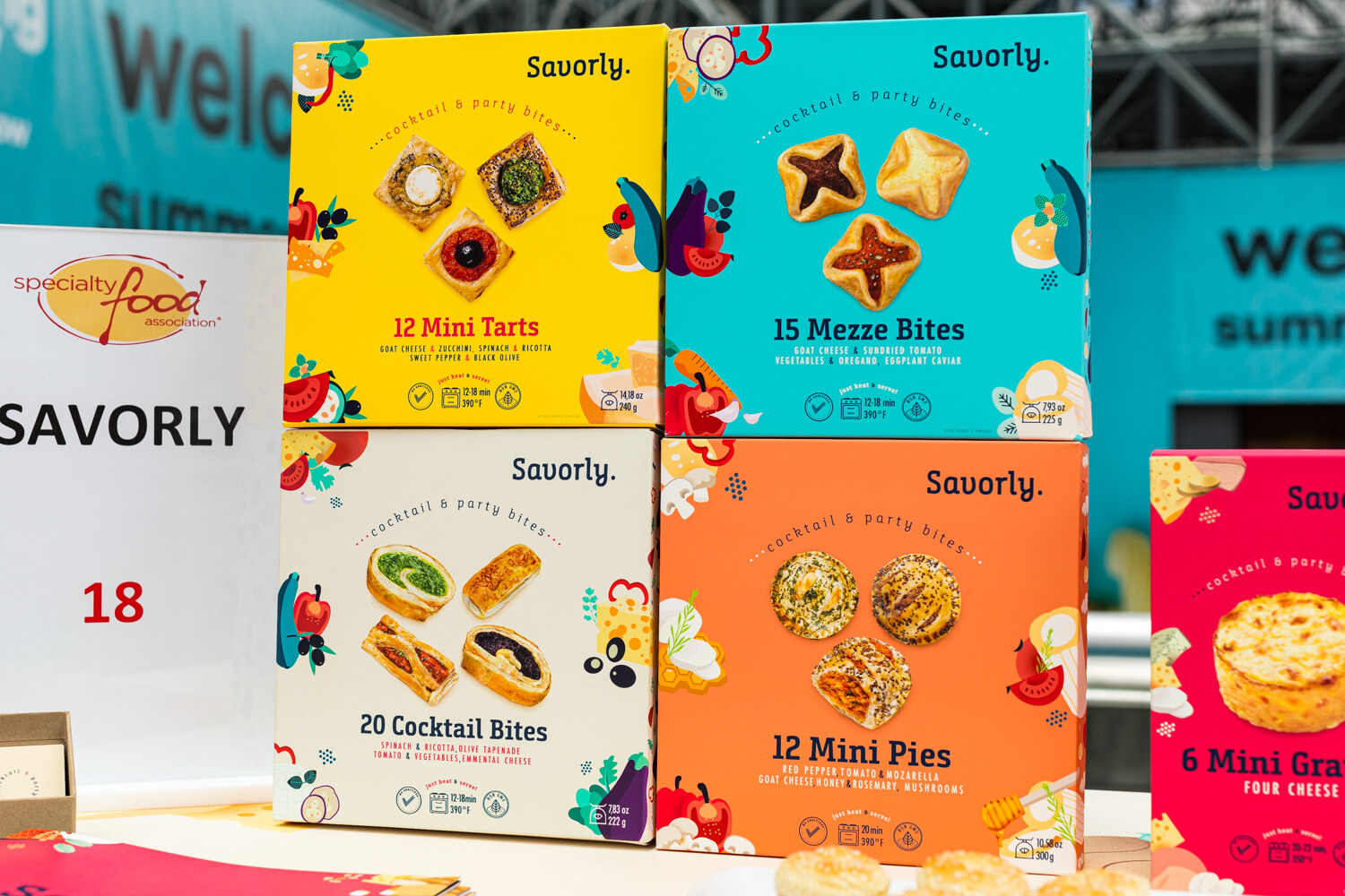 Photo of Savorly cocktail party bite boxes in front of a Specialty Food Association sign.