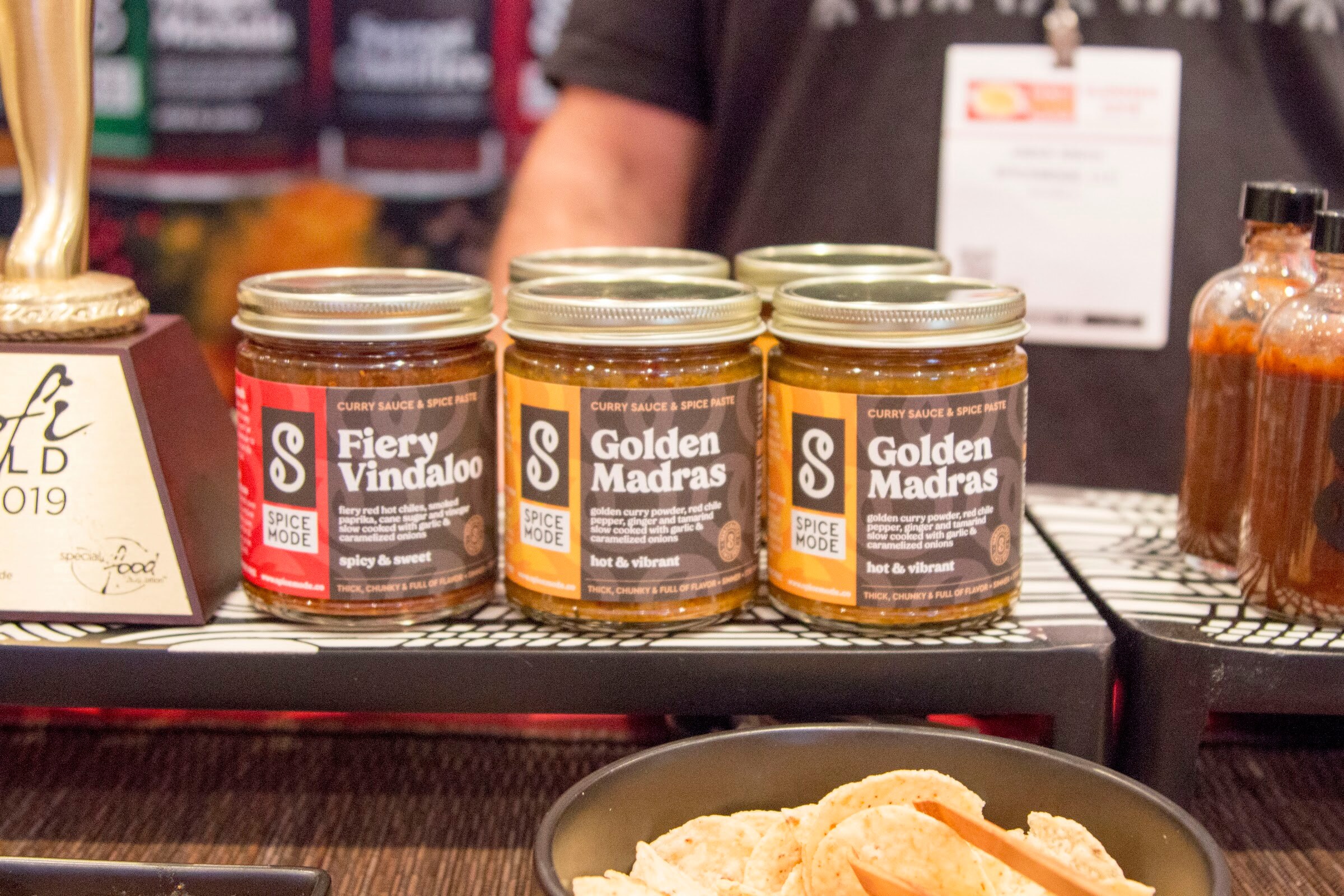 Photo of jars of Spice Mode curry sauces beside a sofi 2019 award trophy.