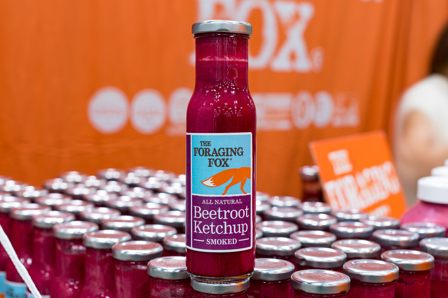 Photo of a bottle of The Foraging Fox smoked beetroot ketchup above rows of jars.