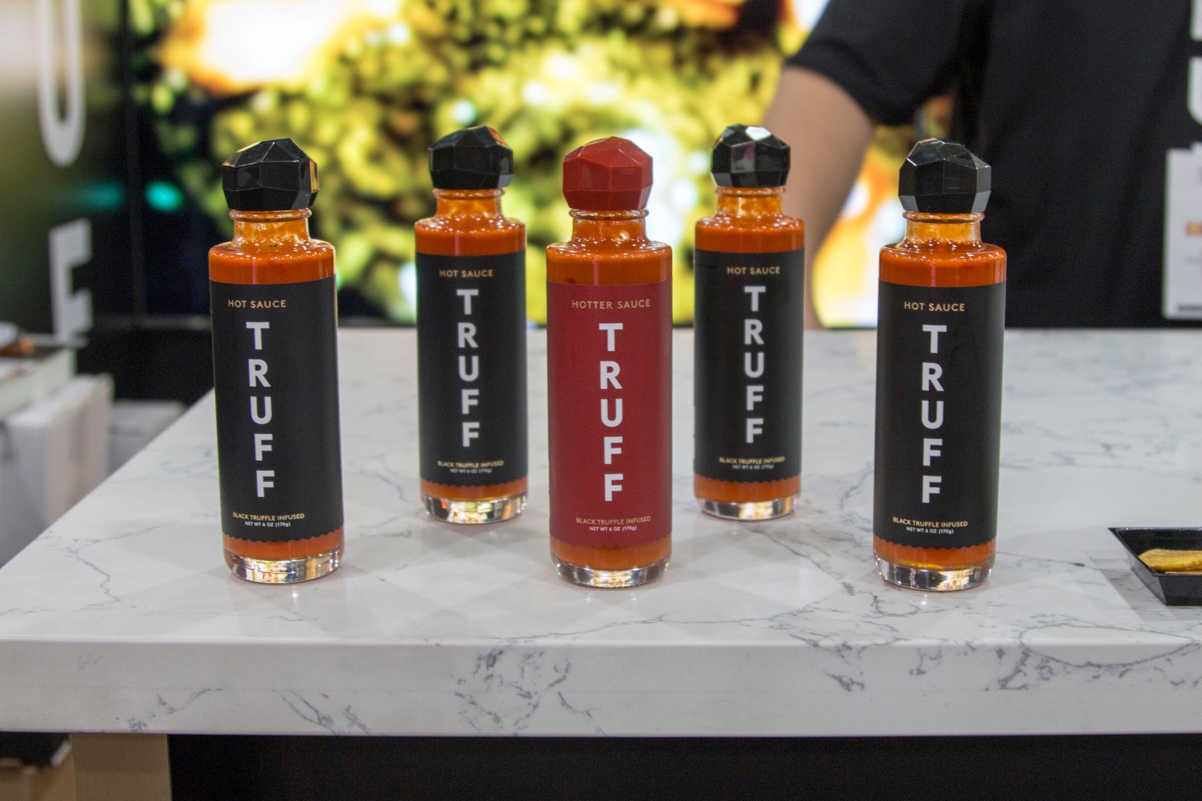 Photo of five bottles of Truff hot sauce on a marble counter.