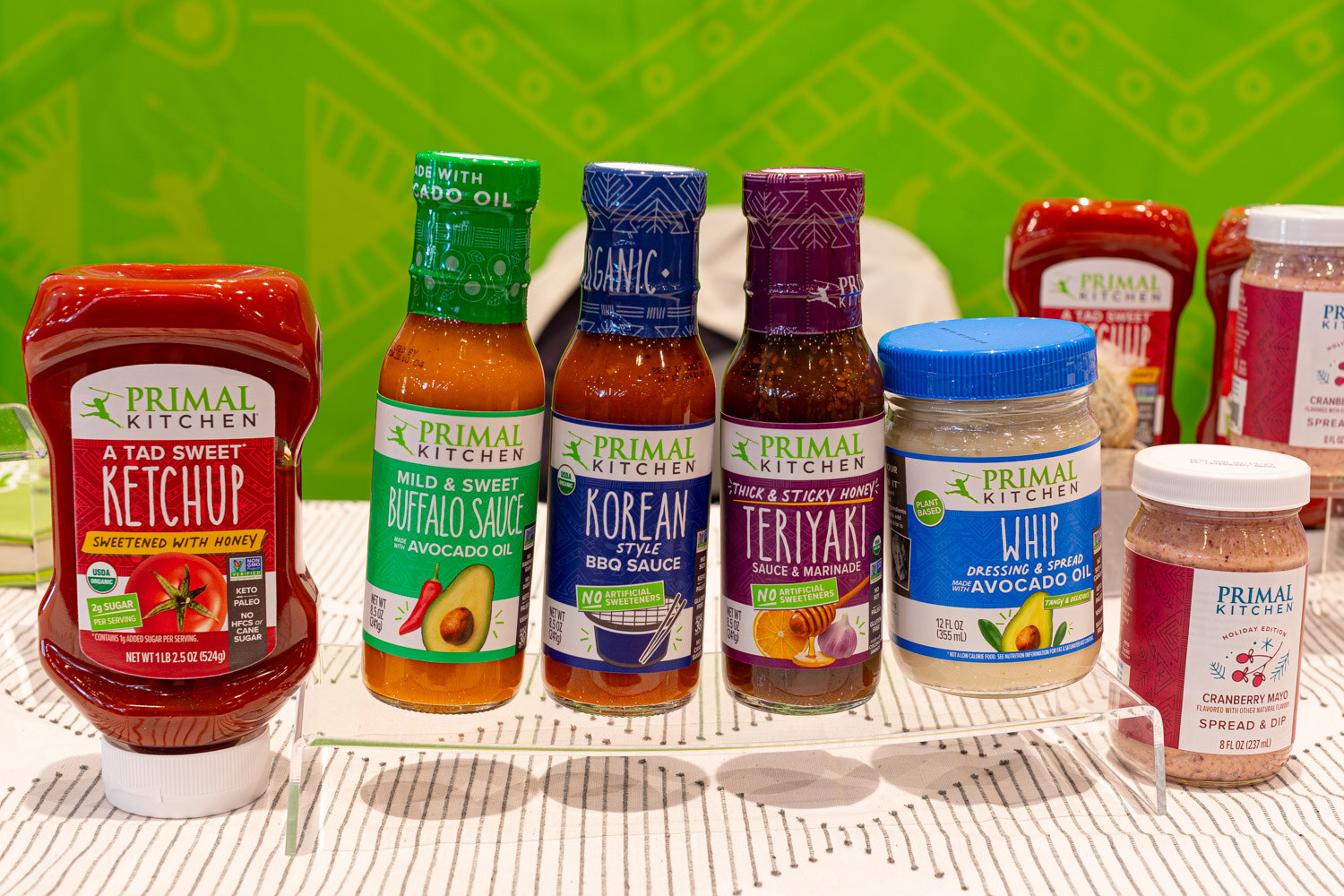 Primal Kitchen ketchup, buffalo sauce, Korean BBQ sauce, teriyaki and avocado oil whip stand on a tiered display
