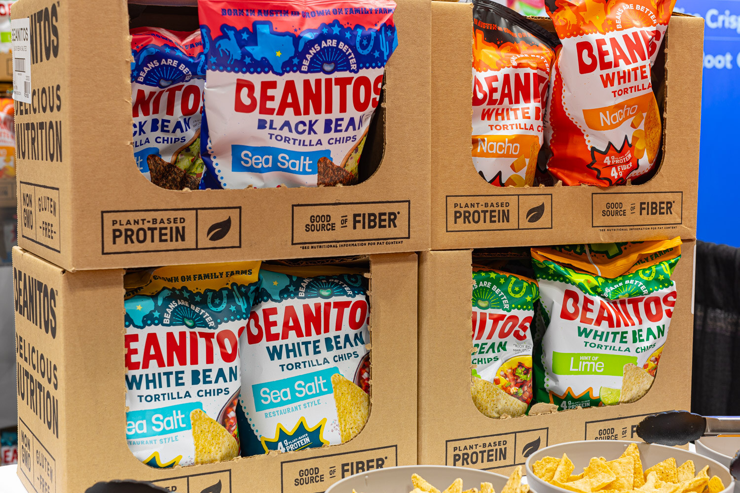Boxes and bags of Beanitos black bean and white bean tortilla chips in Sea Salt, Nacho and Lime flavors