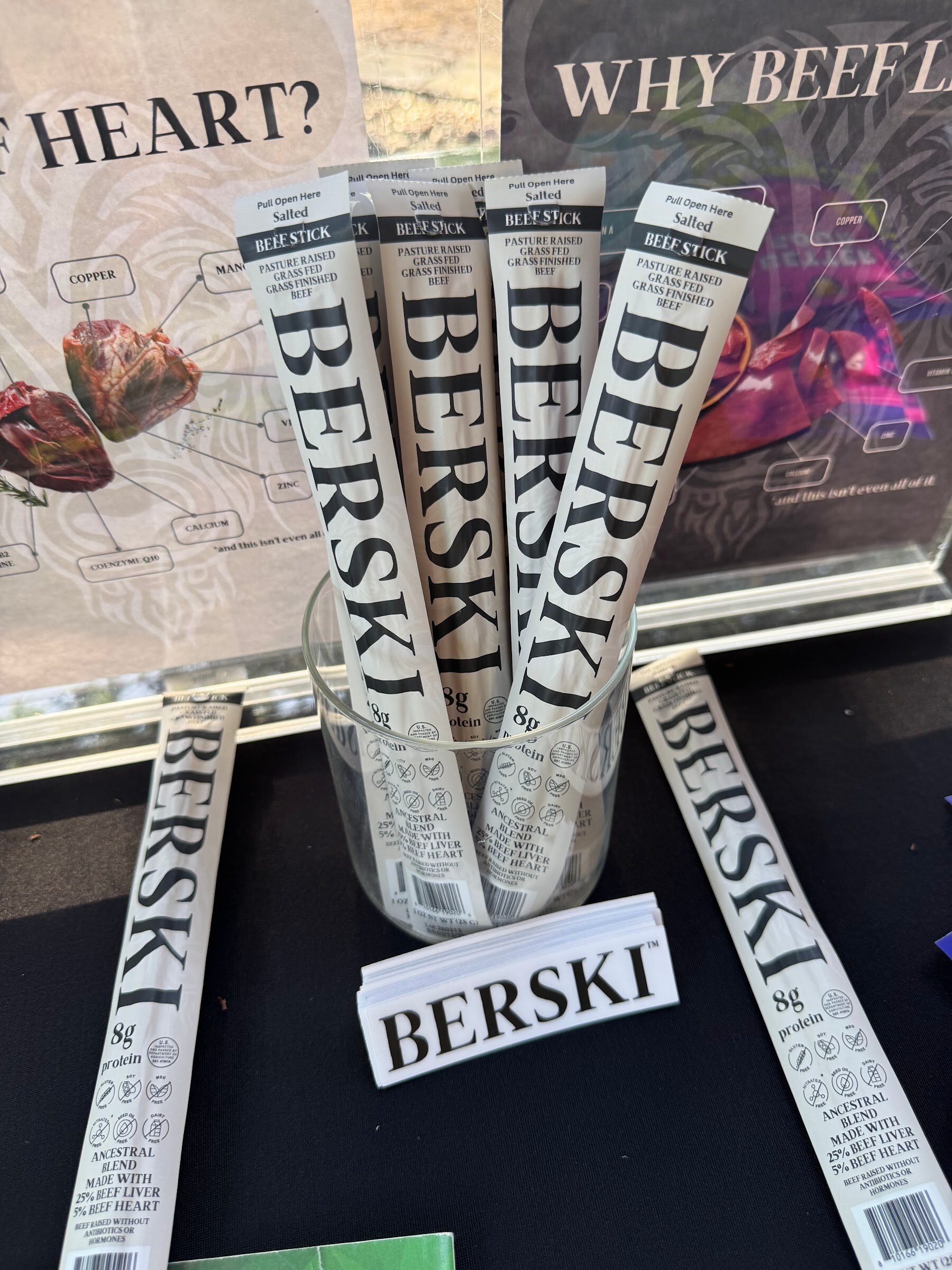 Three Berski sticks displayed in front of a Berski sign on a table.
