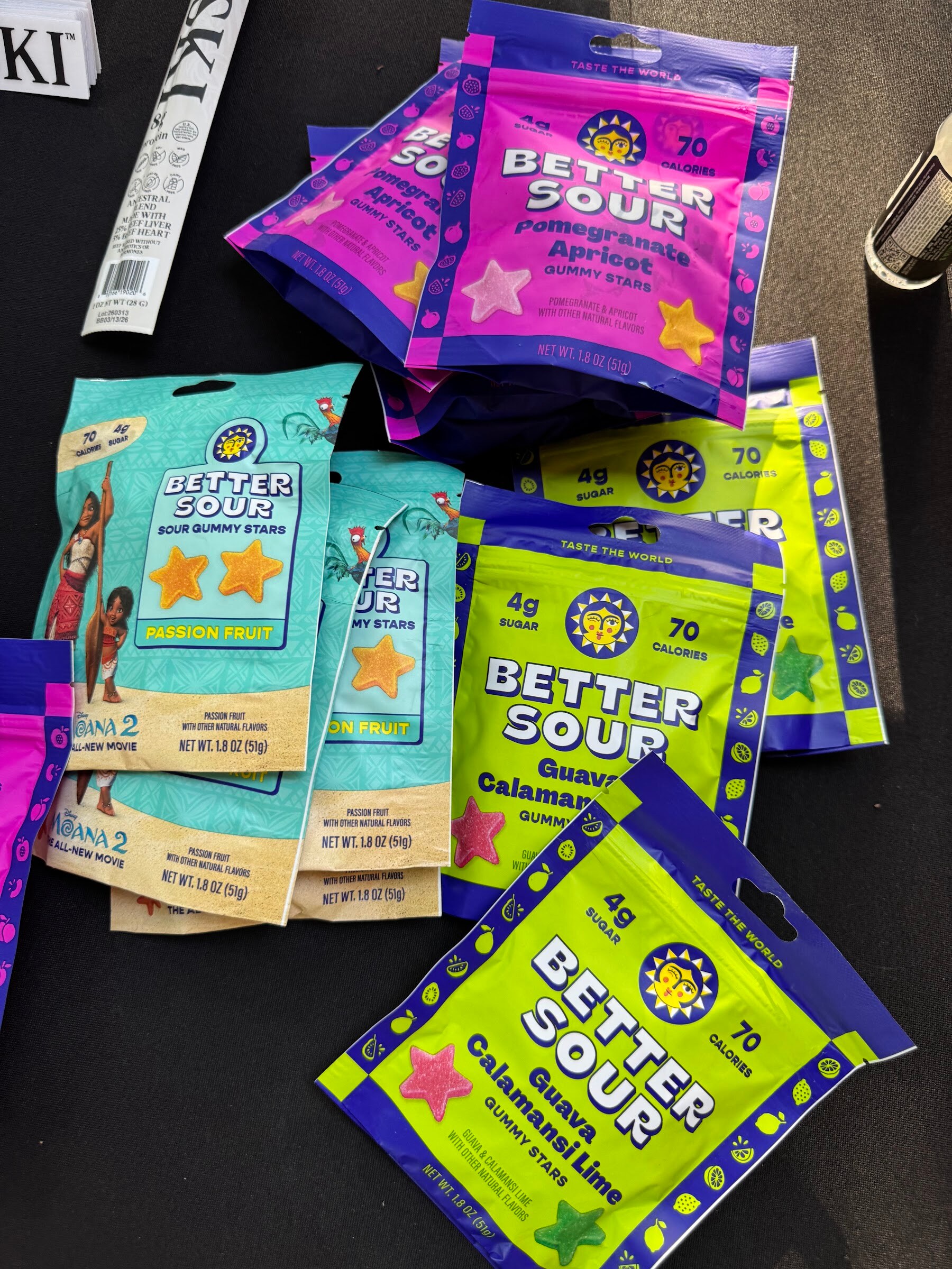 Pile of Better Sour candy pouches in purple, green and blue.